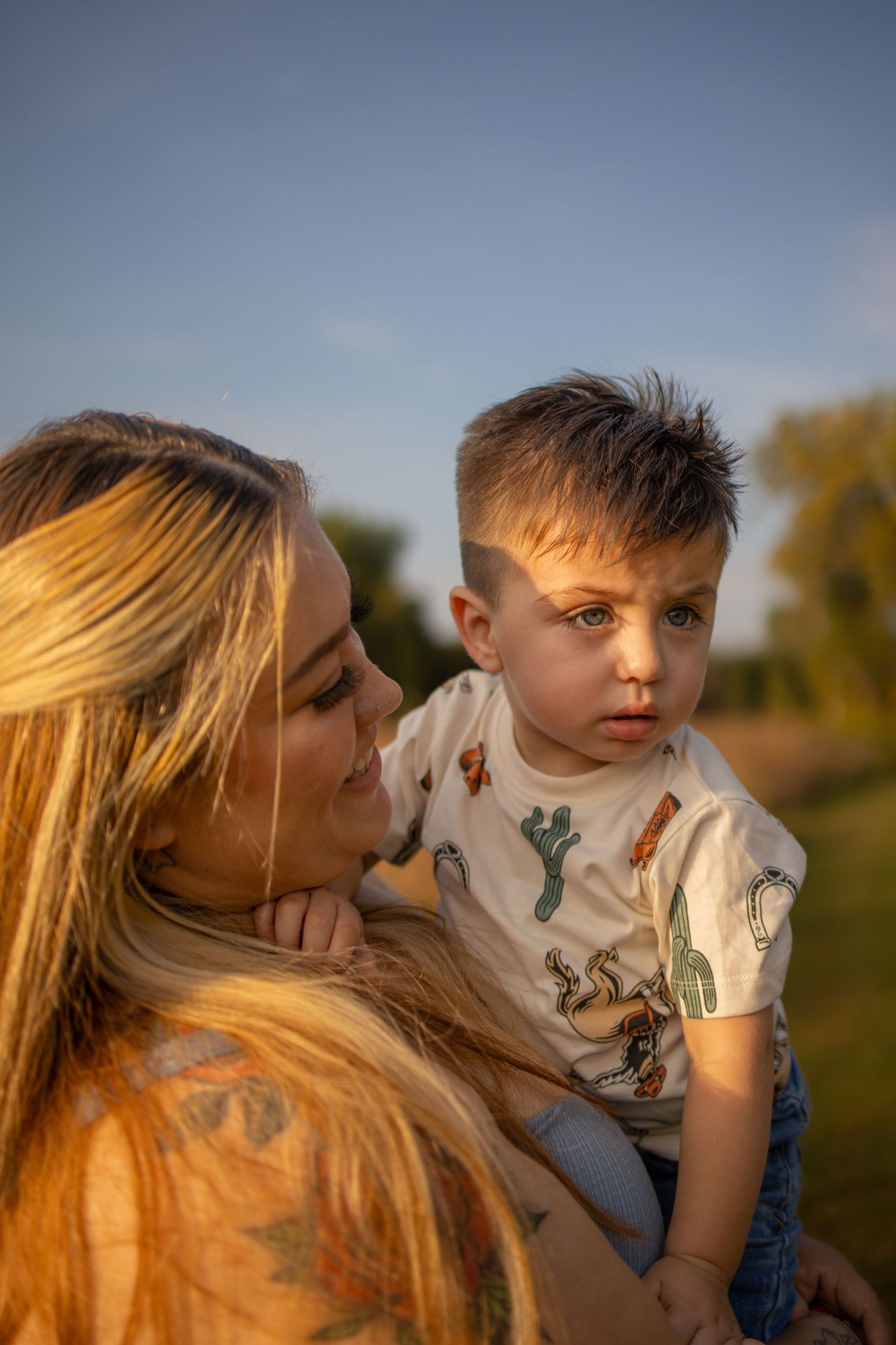 A beautiful golden sunlit sequence shows tender interaction between parent and child in an outdoor setting at sunset.