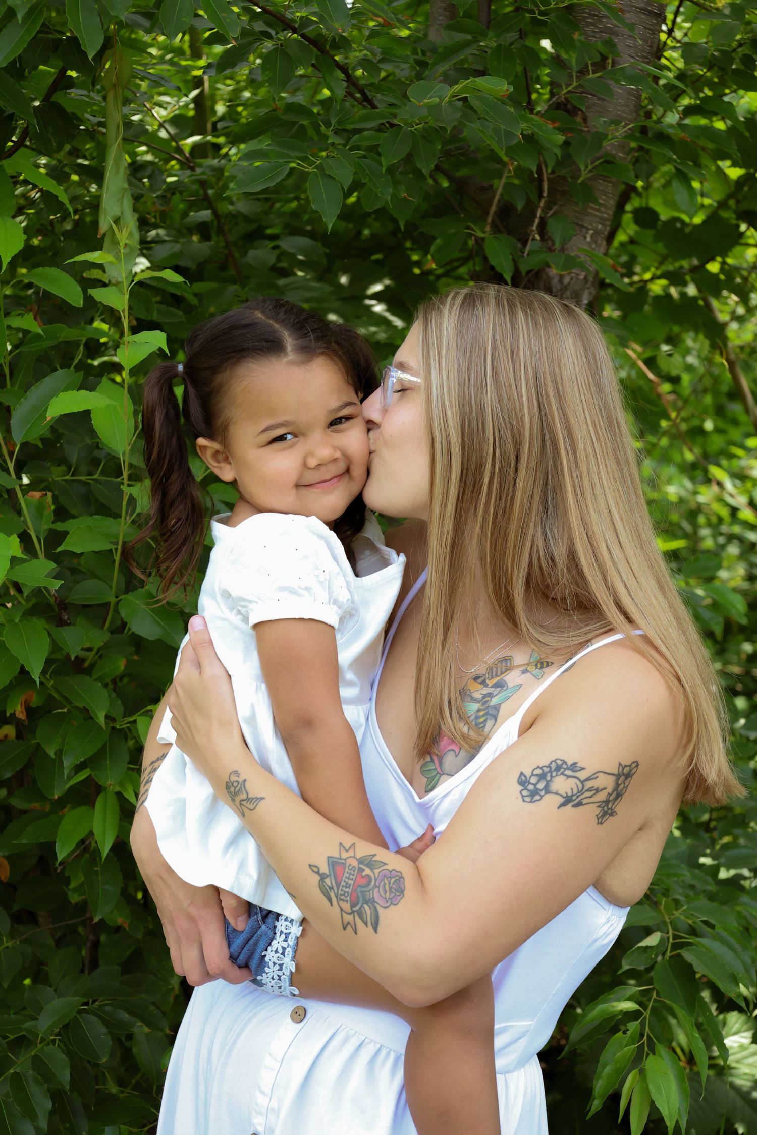 Loving moment between parent and child outdoors with green leafy background in summer.