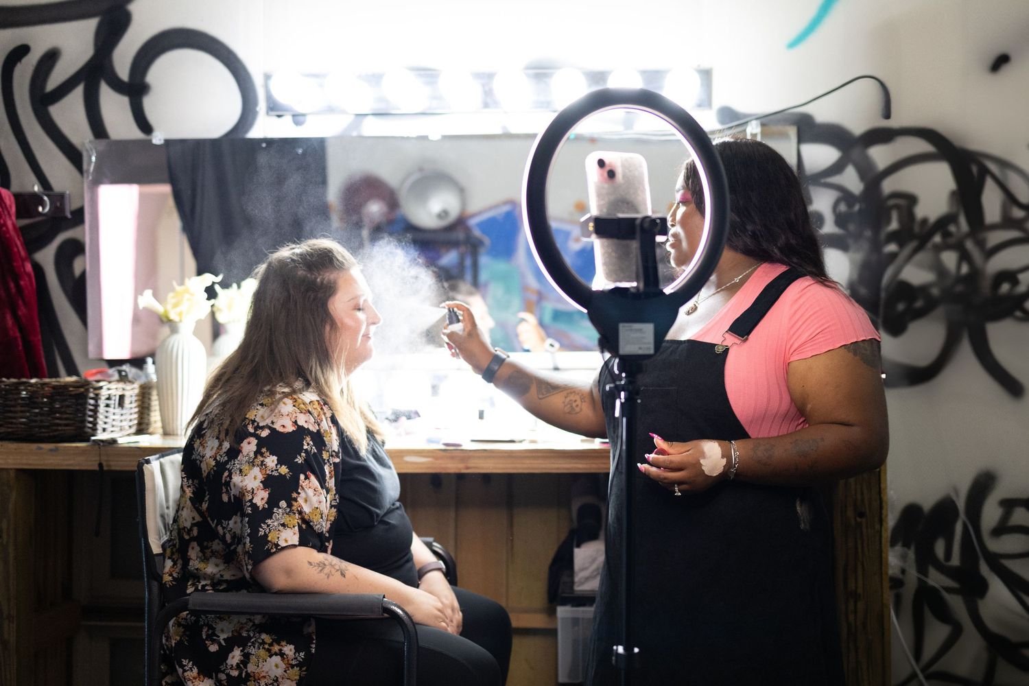 Behind the scenes photo of a content creator filming with ring light and professional setup in a studio setting.
