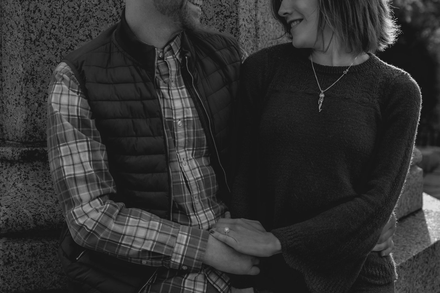 A series of black and white photographs showing people embracing and interacting outdoors in casual attire.