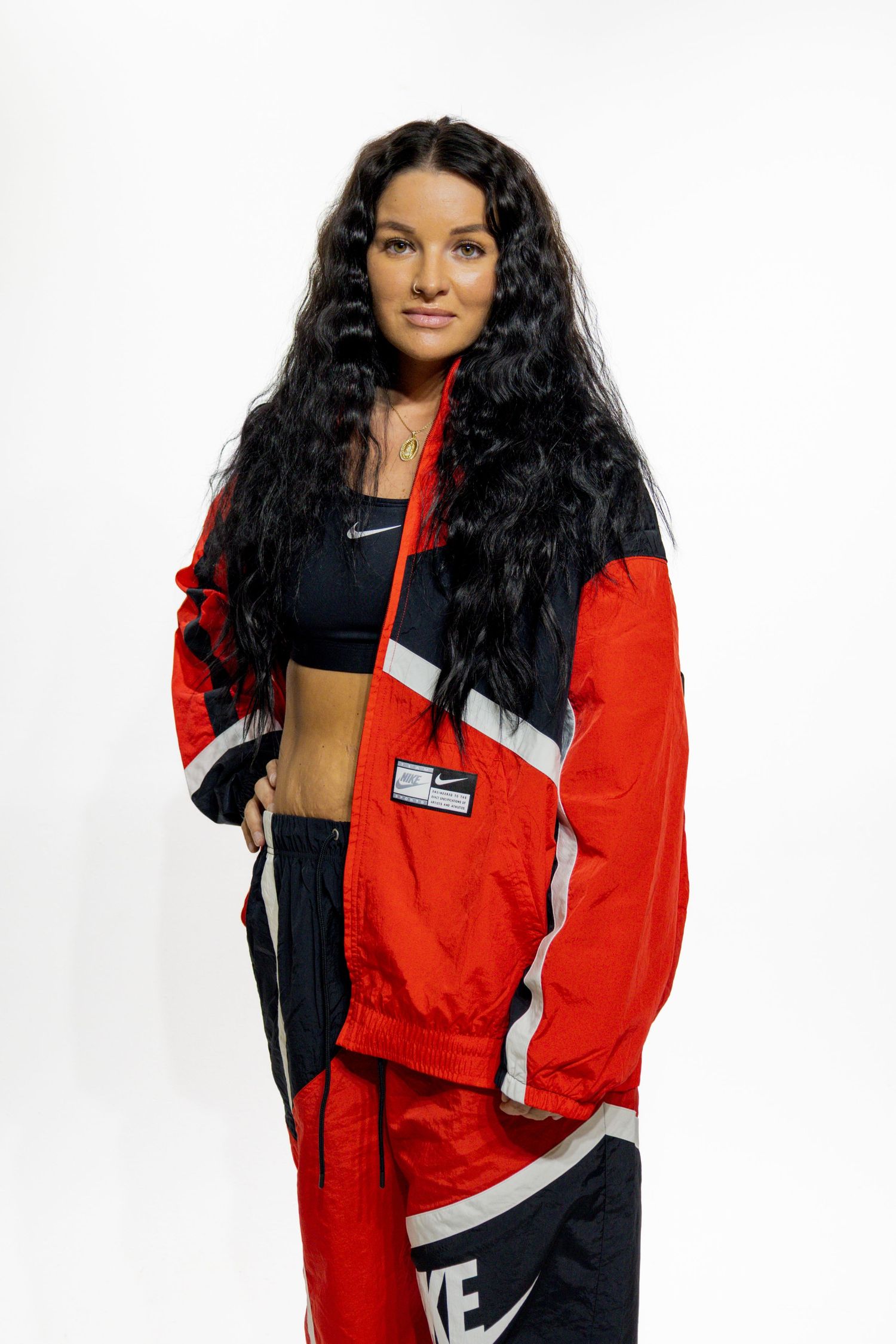 A fashion photo sequence showing a red and black Nike athletic jacket from multiple angles.