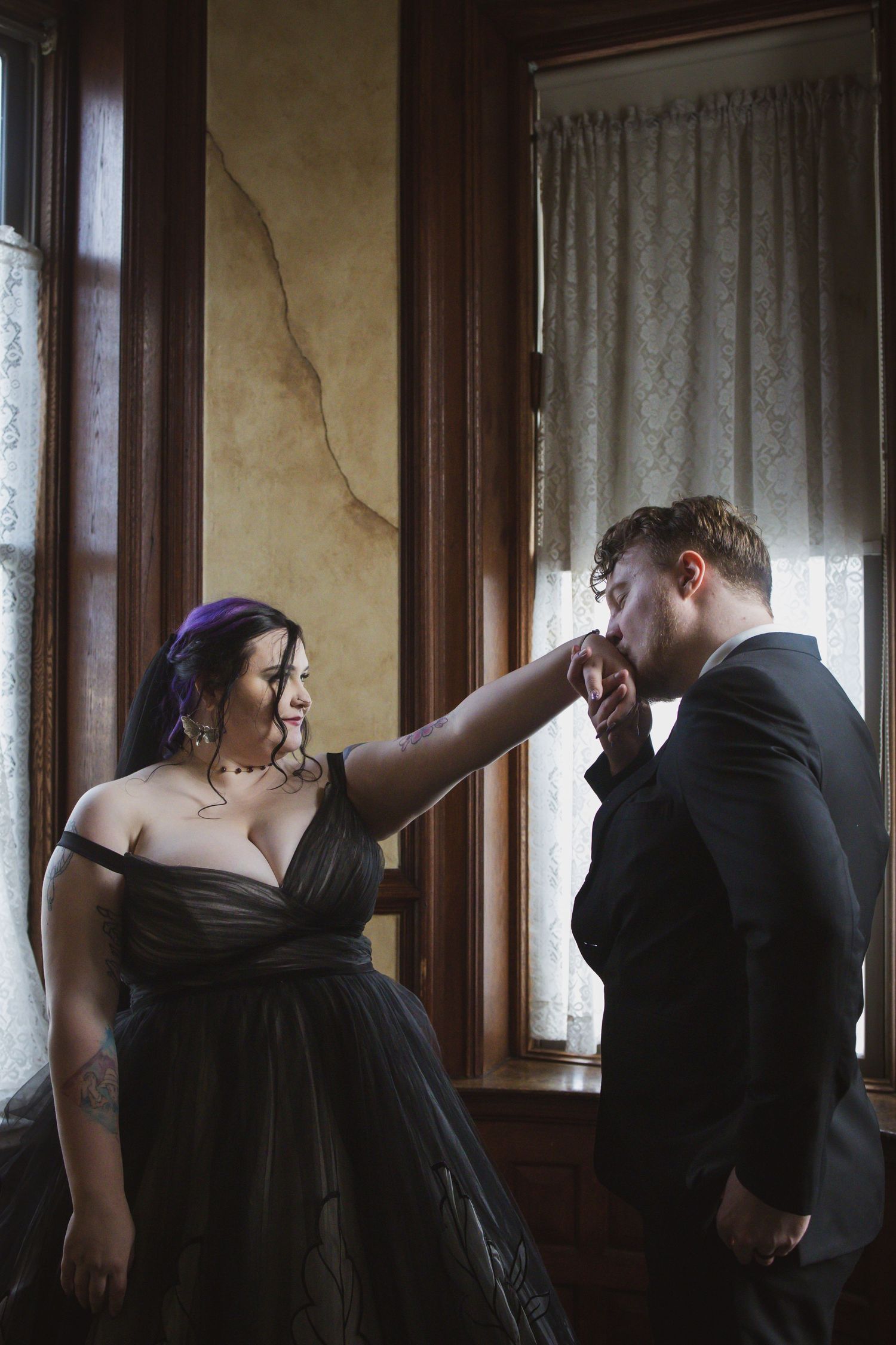 A series of photos showing a couple in a romantic sequence by a window wearing black formal attire.