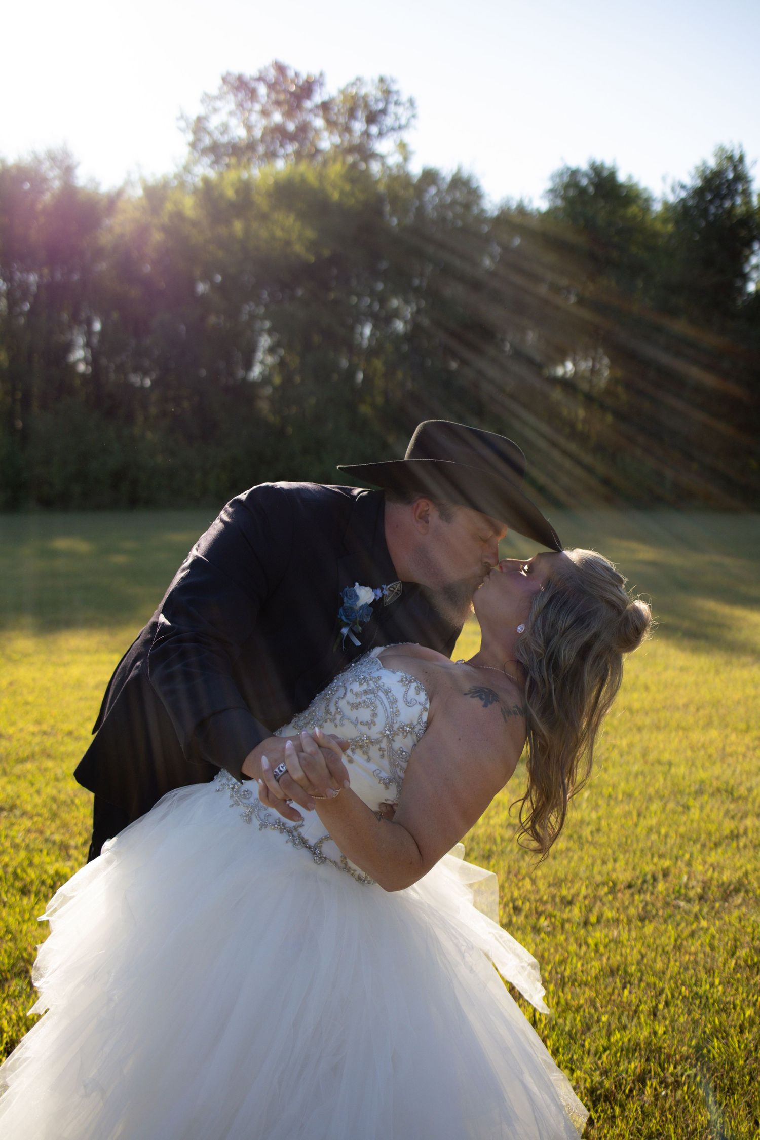 A romantic sequence of photos shows a couple sharing a tender kiss in a sunlit field at golden hour.