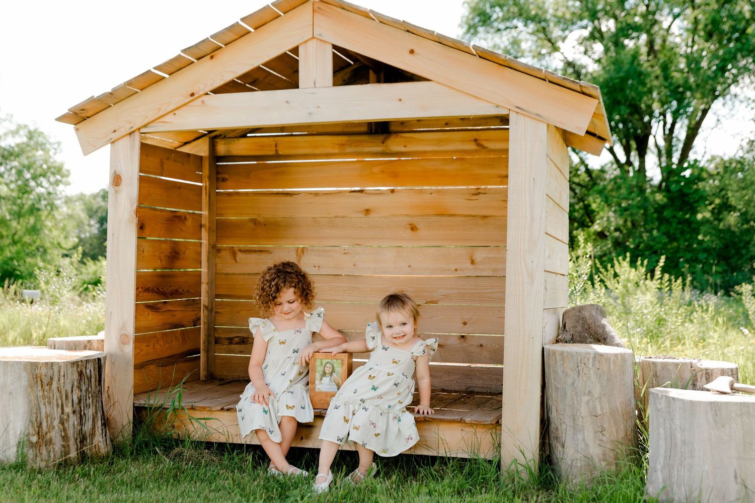A wooden playhouse construction process shown in five progress photos from frame to completion in a backyard setting.