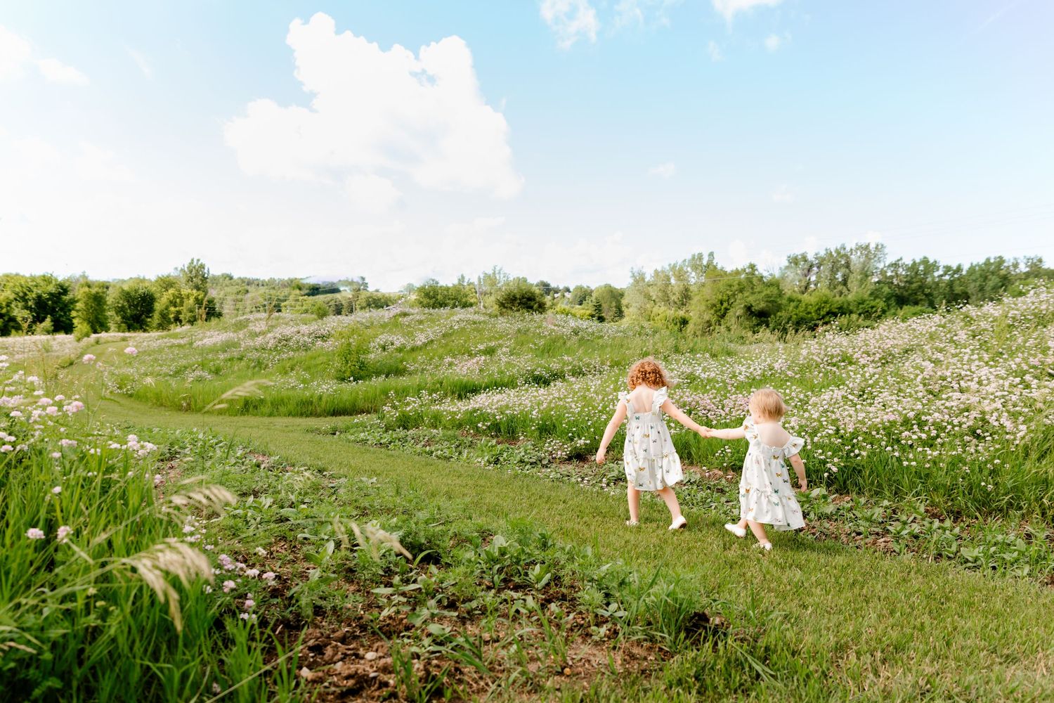 A sequence of joyful moments in a meadow shows people running and playing together among blooming wild flowers.