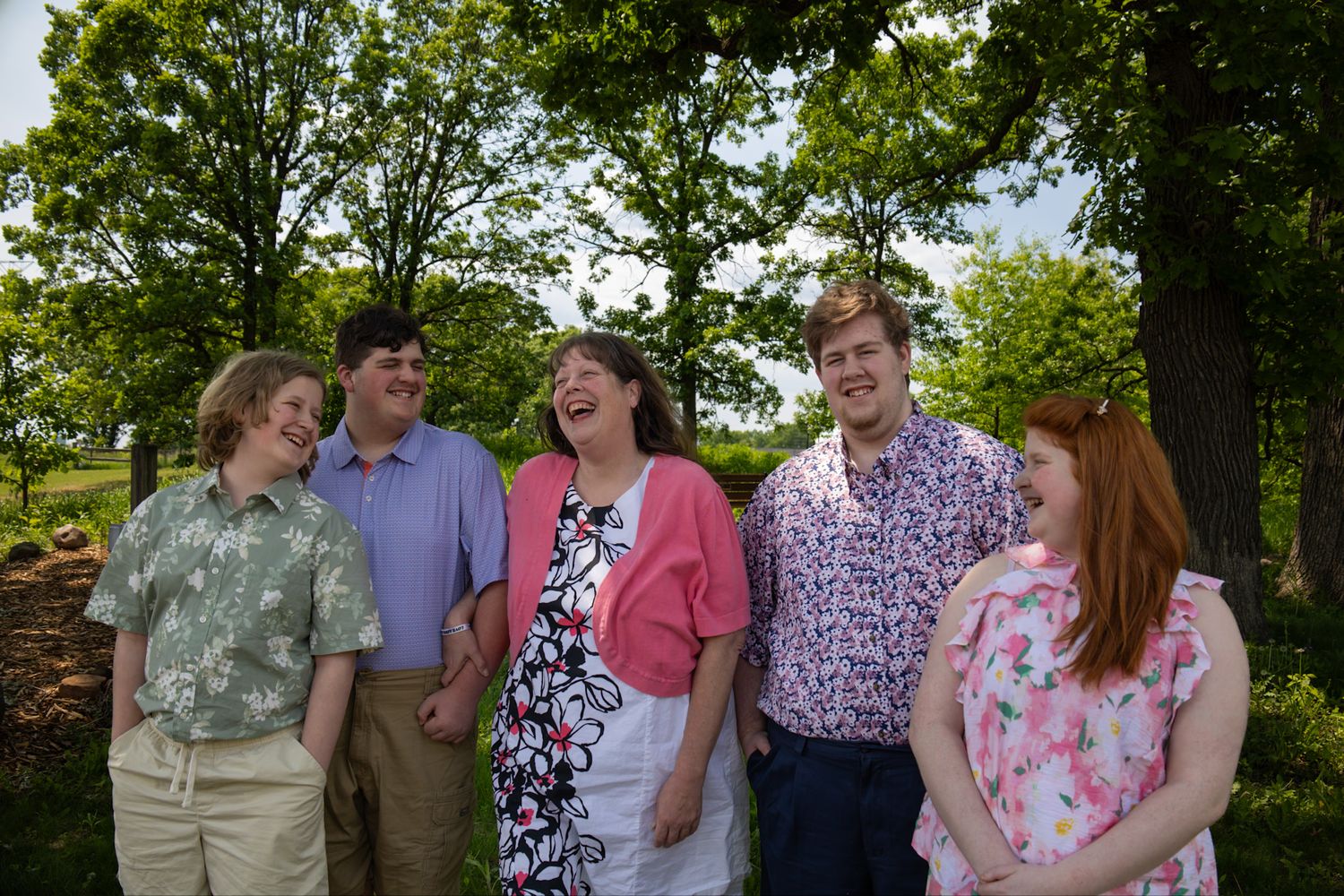 Group enjoying candid moments together outdoors in a garden setting filled with natural greenery.