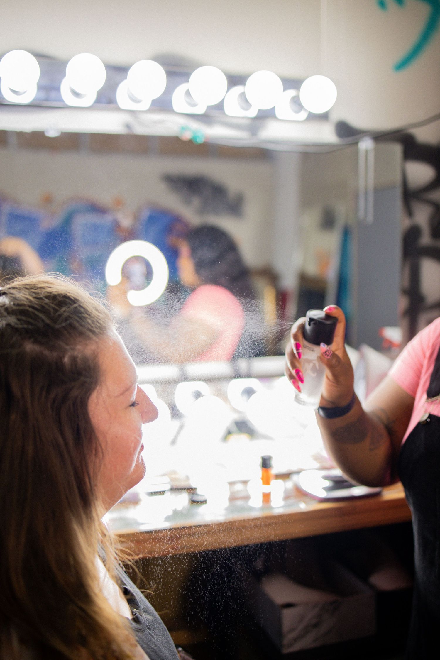 Five sequential blurry shots show someone applying makeup in a dimly lit vanity mirror setup.