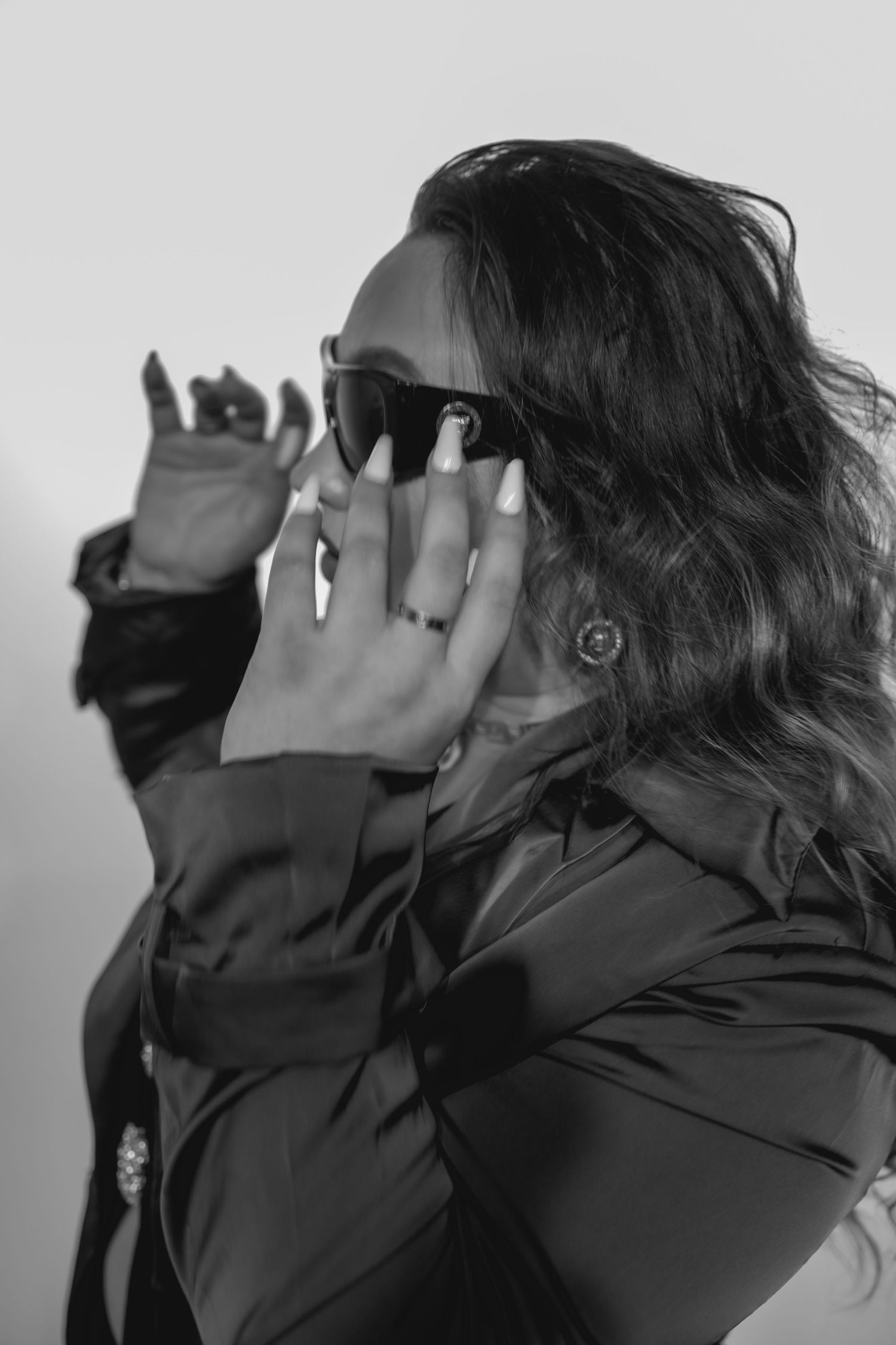 A series of black and white photos showing a person wearing dark clothing covering their face with their hands.