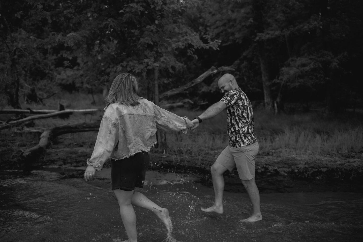 Seven black and white images progressively show splashing and dancing in a shallow stream.