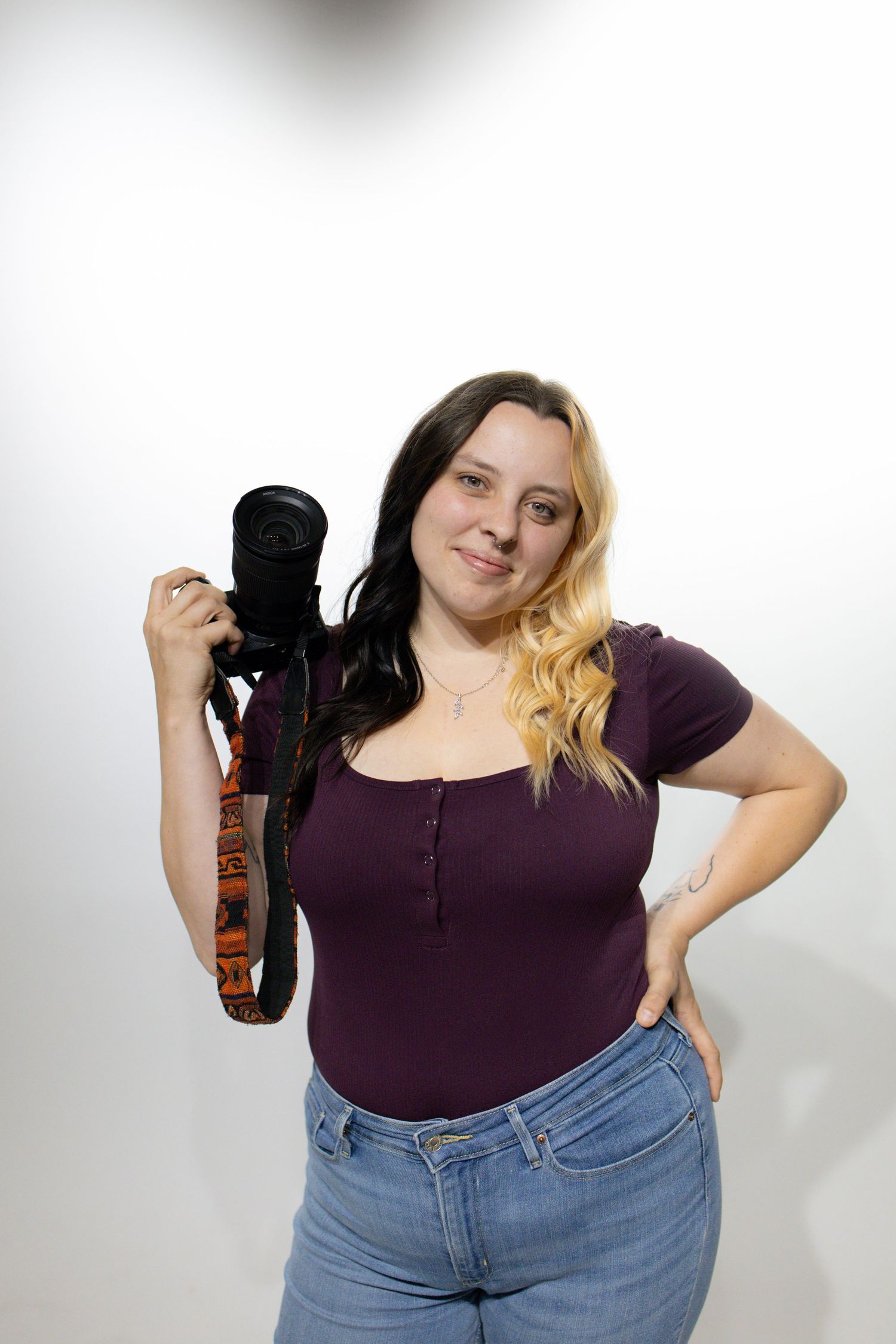 A series of poses with a camera in a studio setting, wearing casual attire and denim.