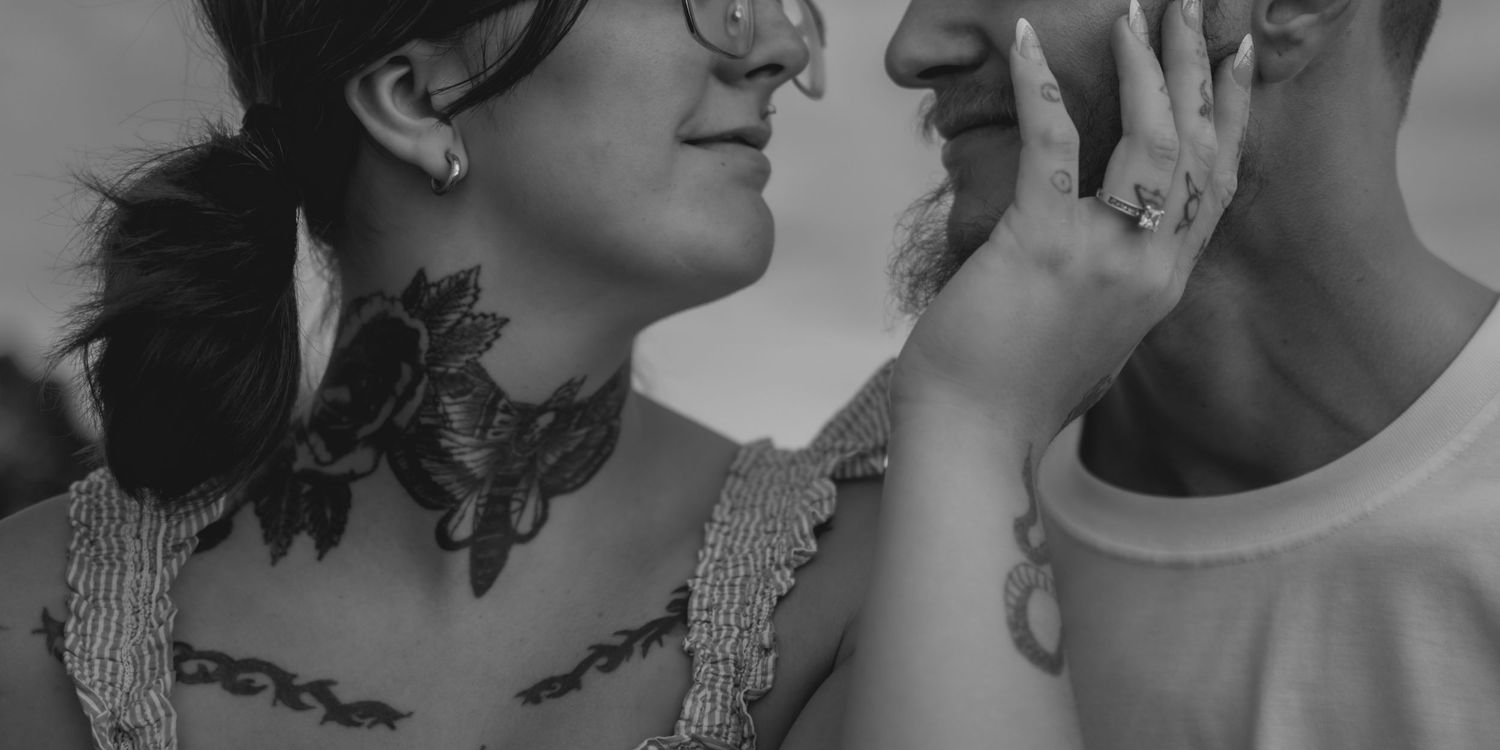 Couple sharing an intimate moment with matching facial expressions and glasses during a wedding photo session.