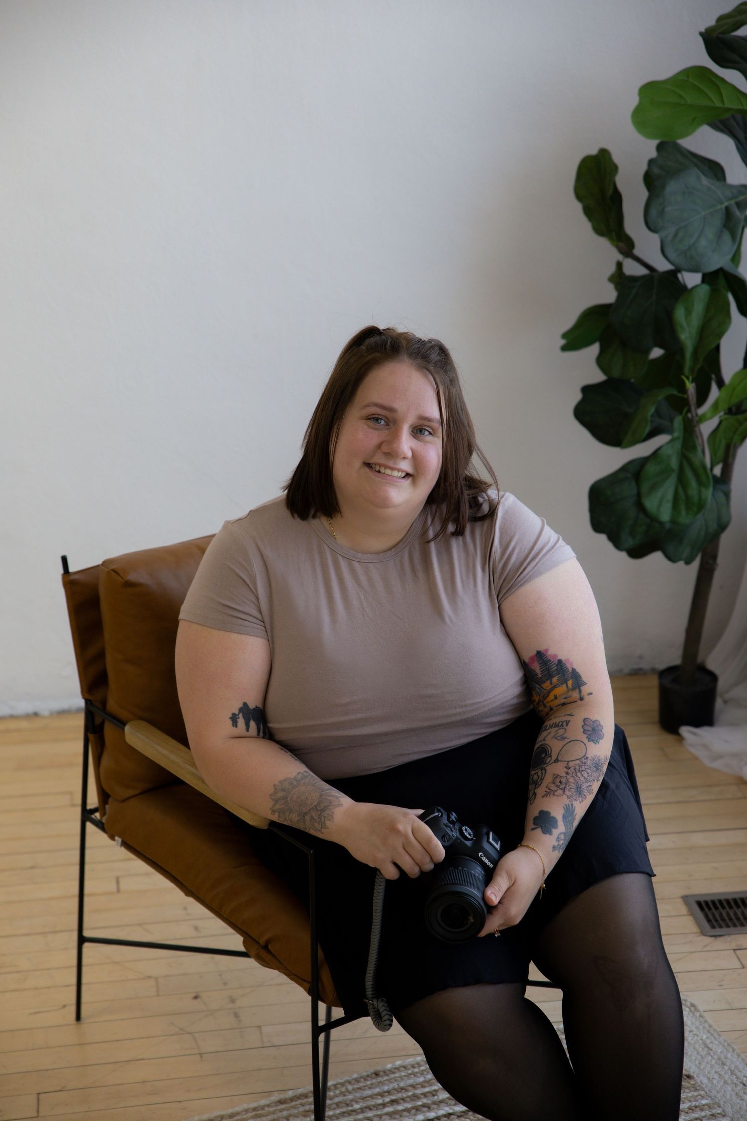 A collection of four similar photos showing someone wearing a tan t-shirt sitting in a wooden chair against a white wall with plants.