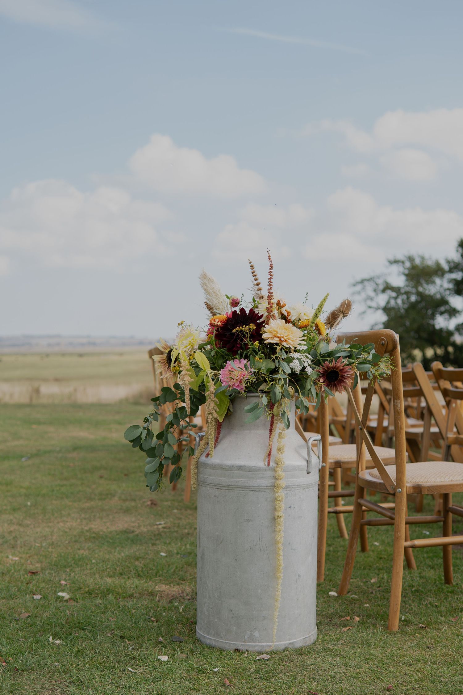 Beautiful milk churn floral display at an outside wedding in Kent | Flowers created by BLOOM Fabulous | Flowers grown in Kent