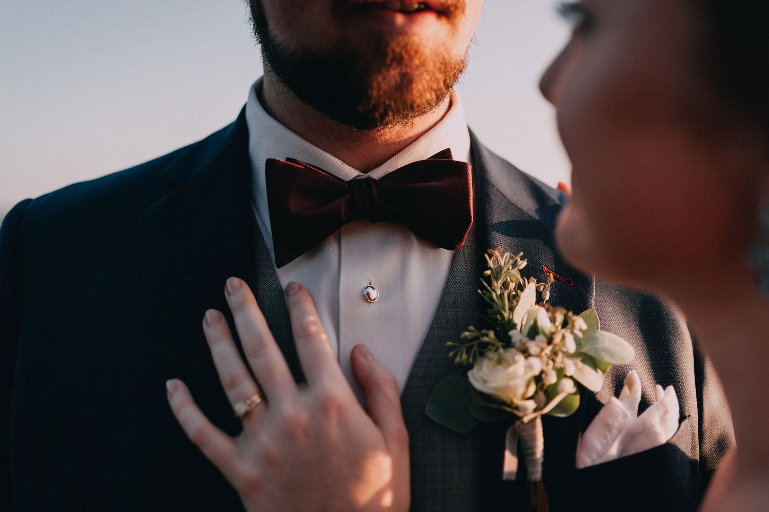 Close-up details of formal black bow tie and white collar.