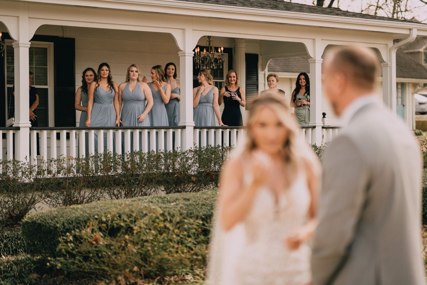 Wedding ceremony takes place on elegant white porch of historic southern home.
