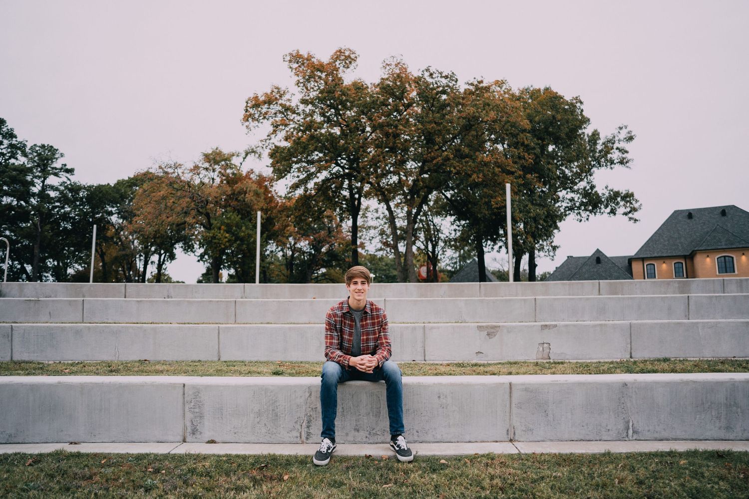 A long concrete wall stretches across a grassy field on an overcast day.