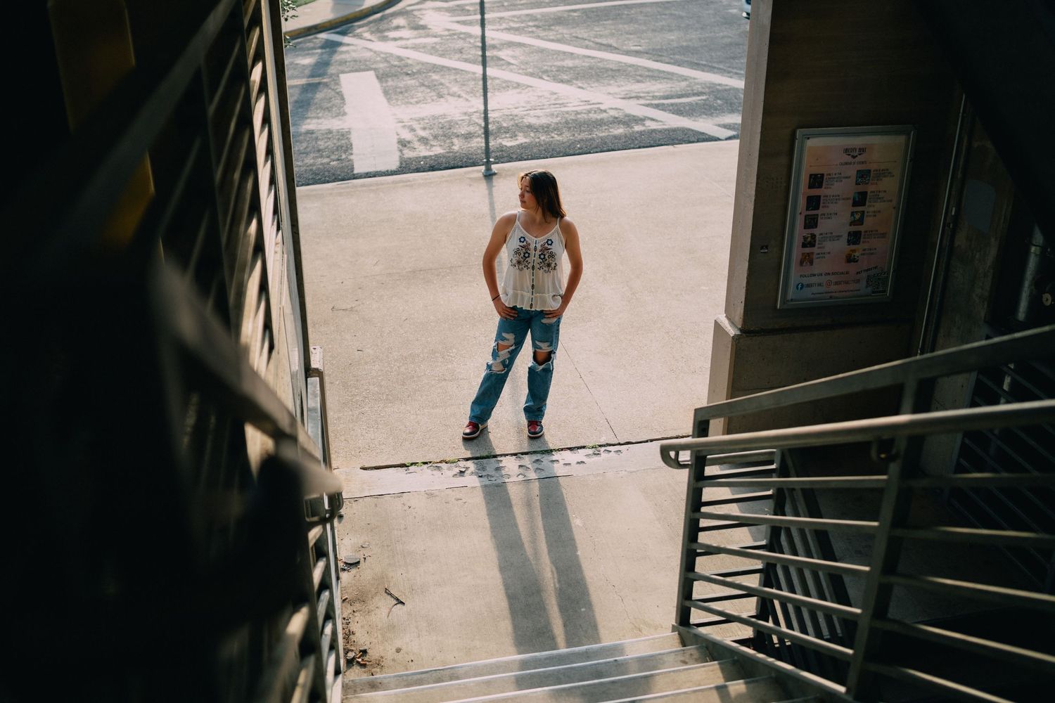An artistic overhead view looking down a stairwell at a figure standing below.