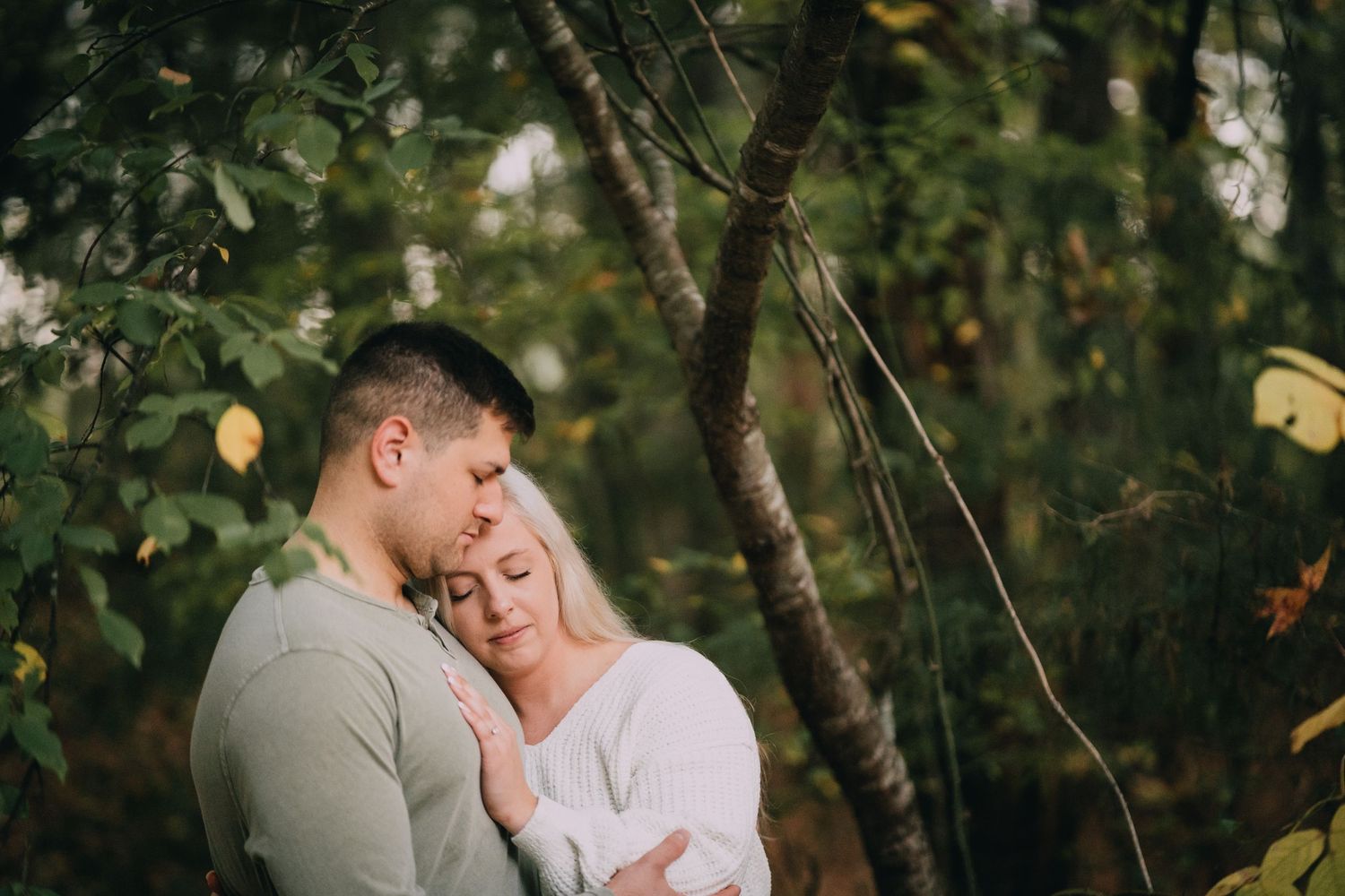 Romantic outdoor couple photoshoot among autumn trees.