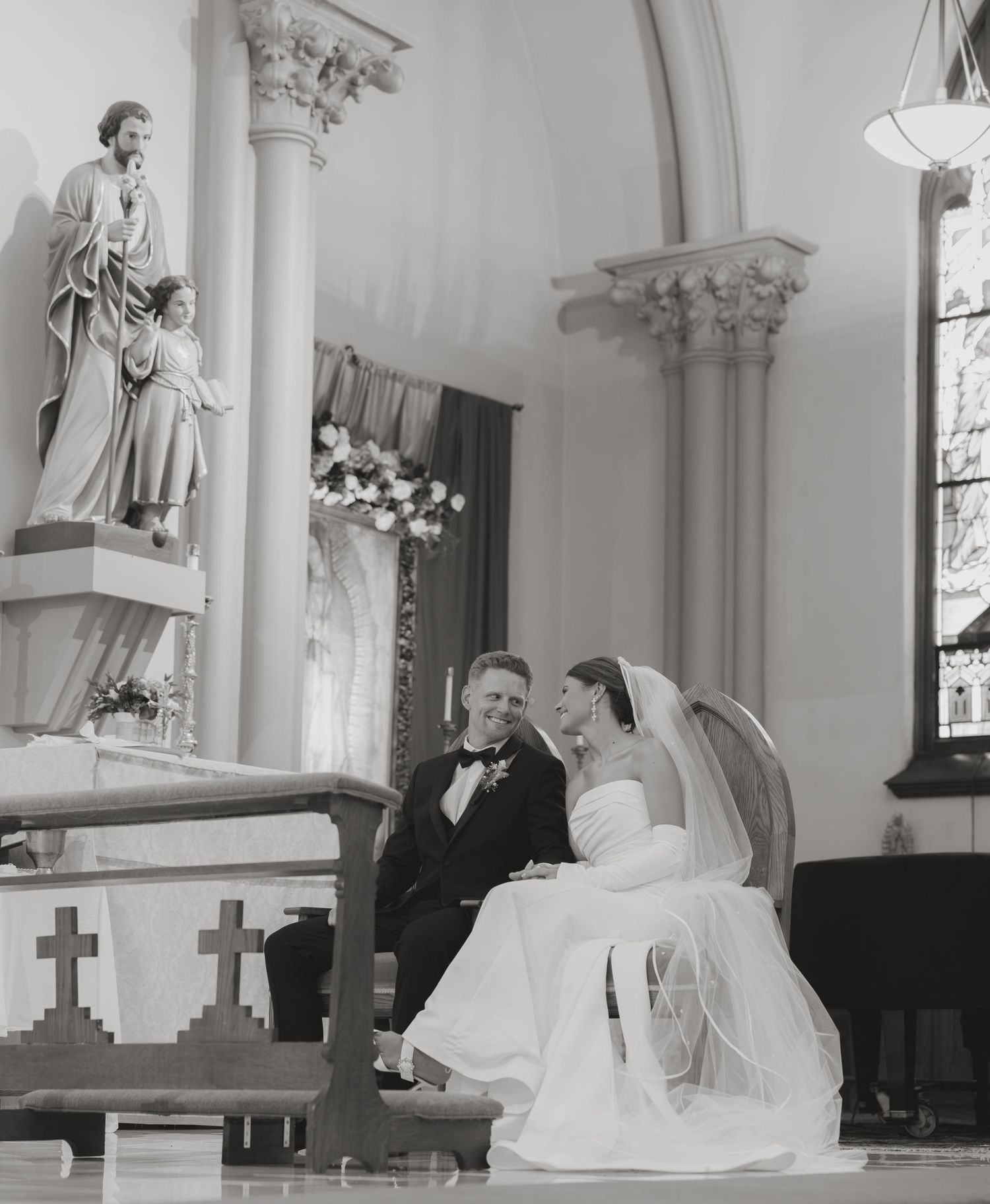 Black and white photo of bride and groom sharing intimate moment at church altar.
