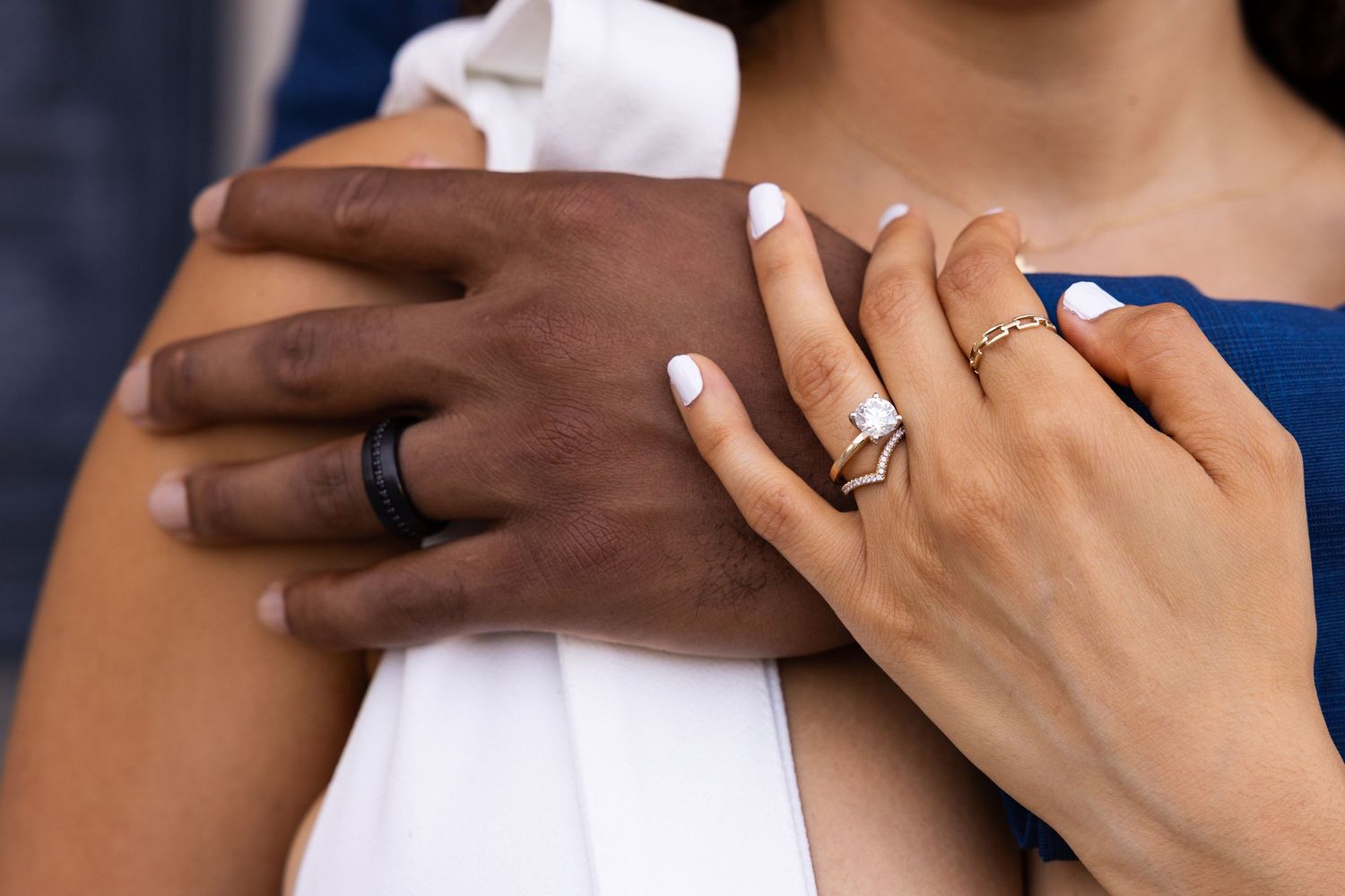 Close up of two hands with wedding rings showing an intimate embrace.