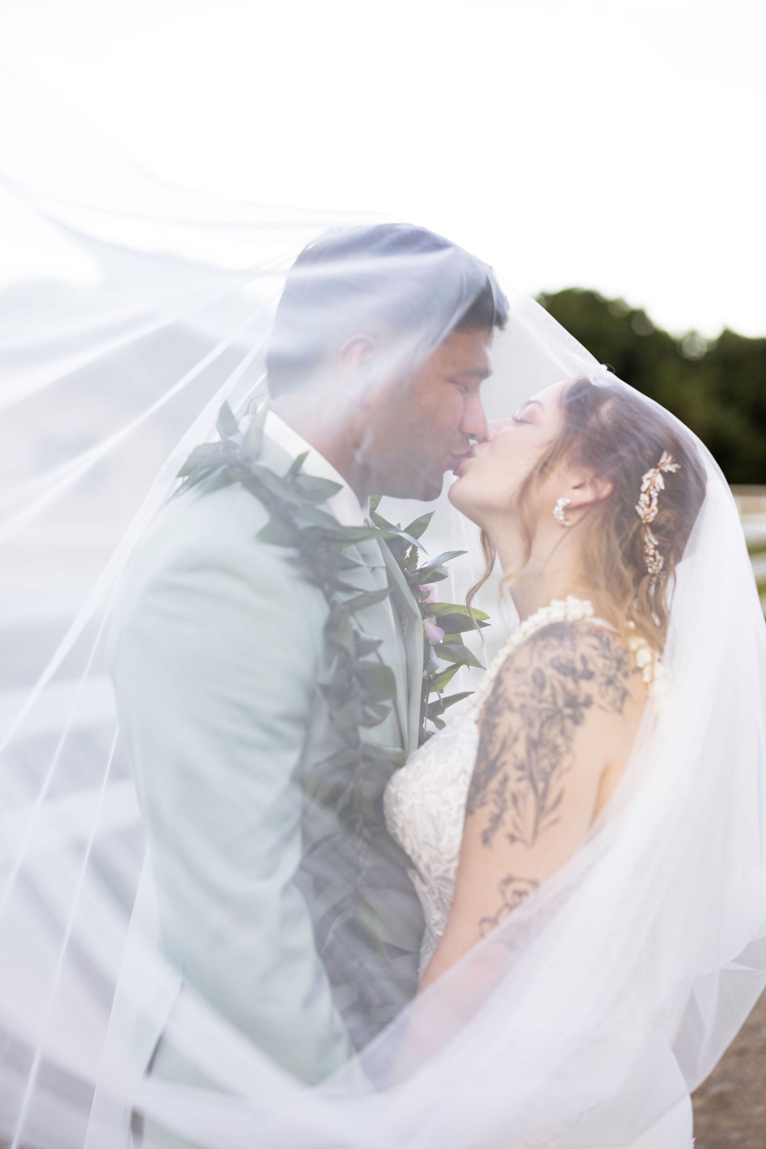 A romantic wedding photoshoot sequence showing tender moments between newlyweds under a flowing white veil.