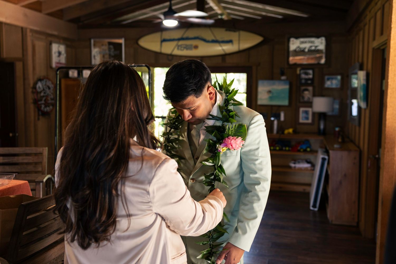 Two people work together to arrange fresh flowers in a rustic wooden interior setting.