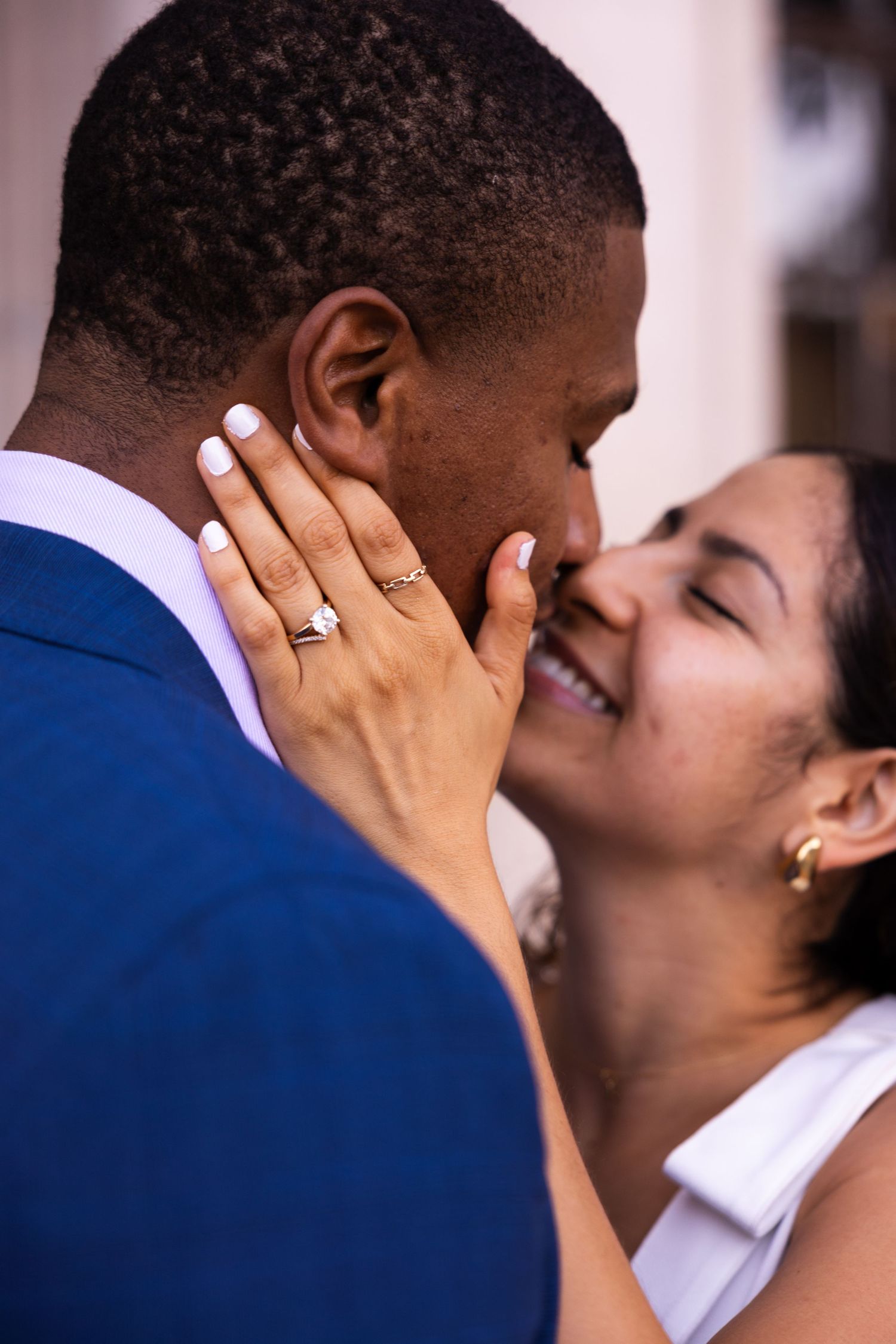 Intimate close-up of newlyweds sharing a tender moment showing wedding rings.