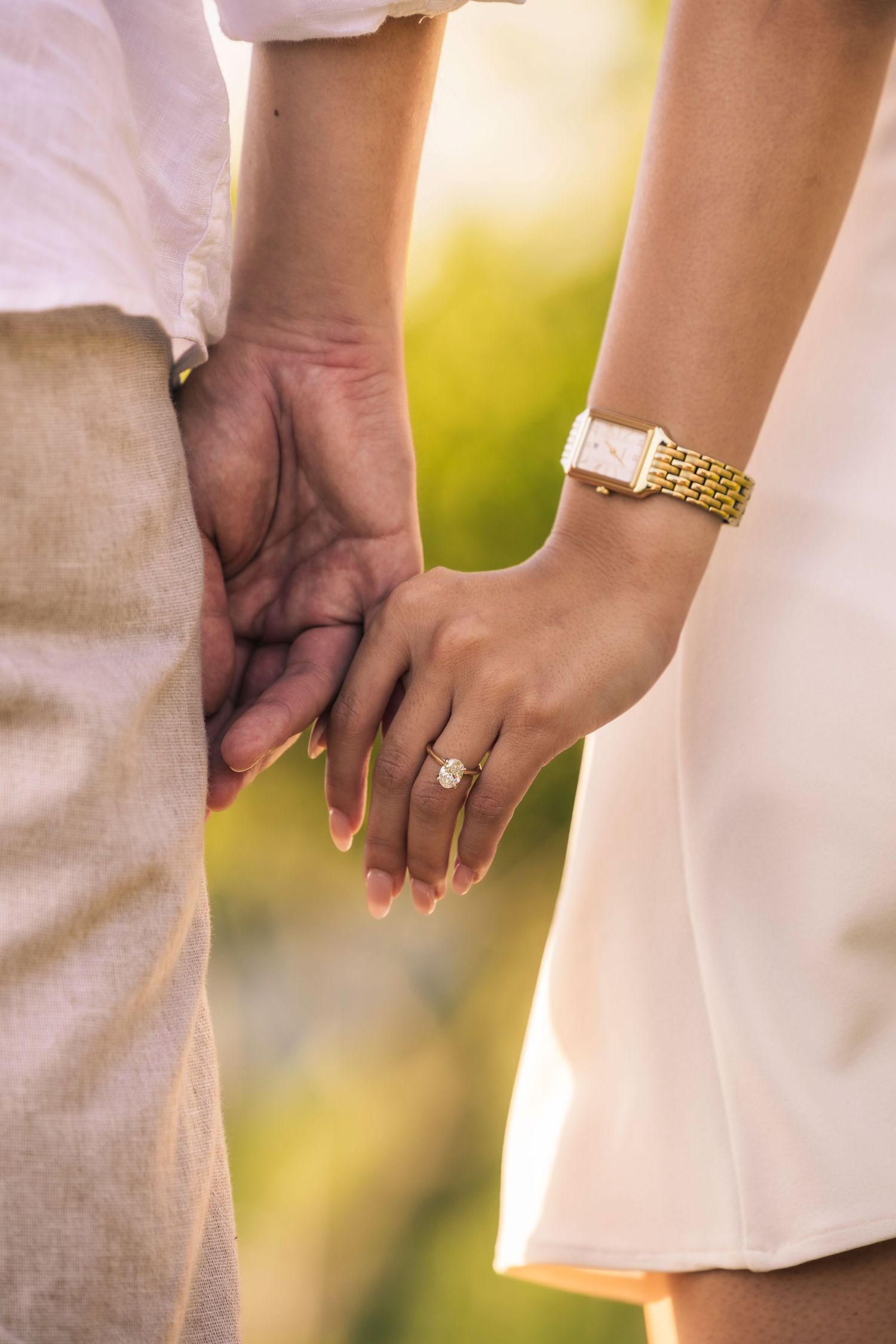 Close-up photo of hands holding each other tenderly against a soft blurred background.
