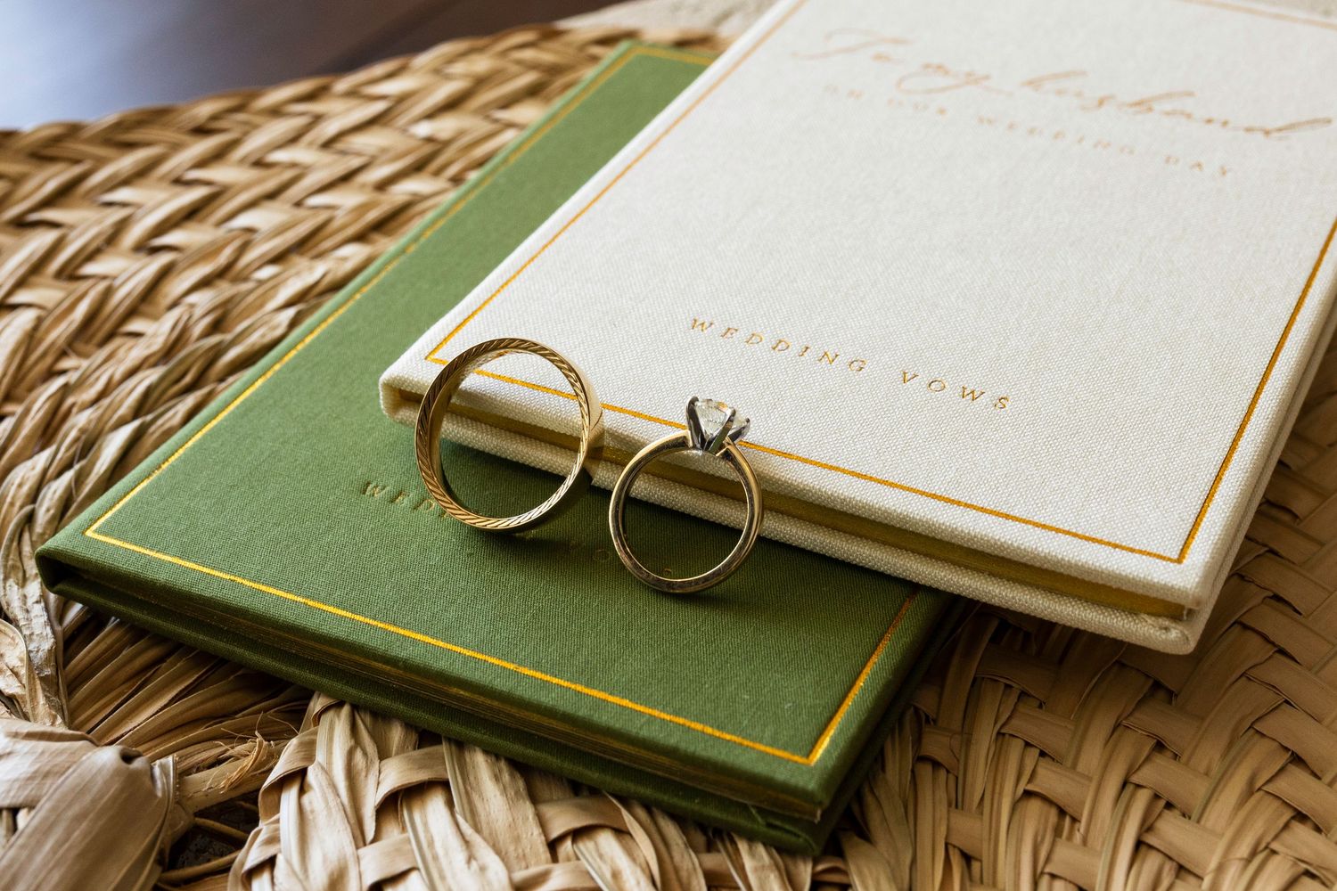 Vintage round glasses rest on stacked books with a woven textured surface beneath.