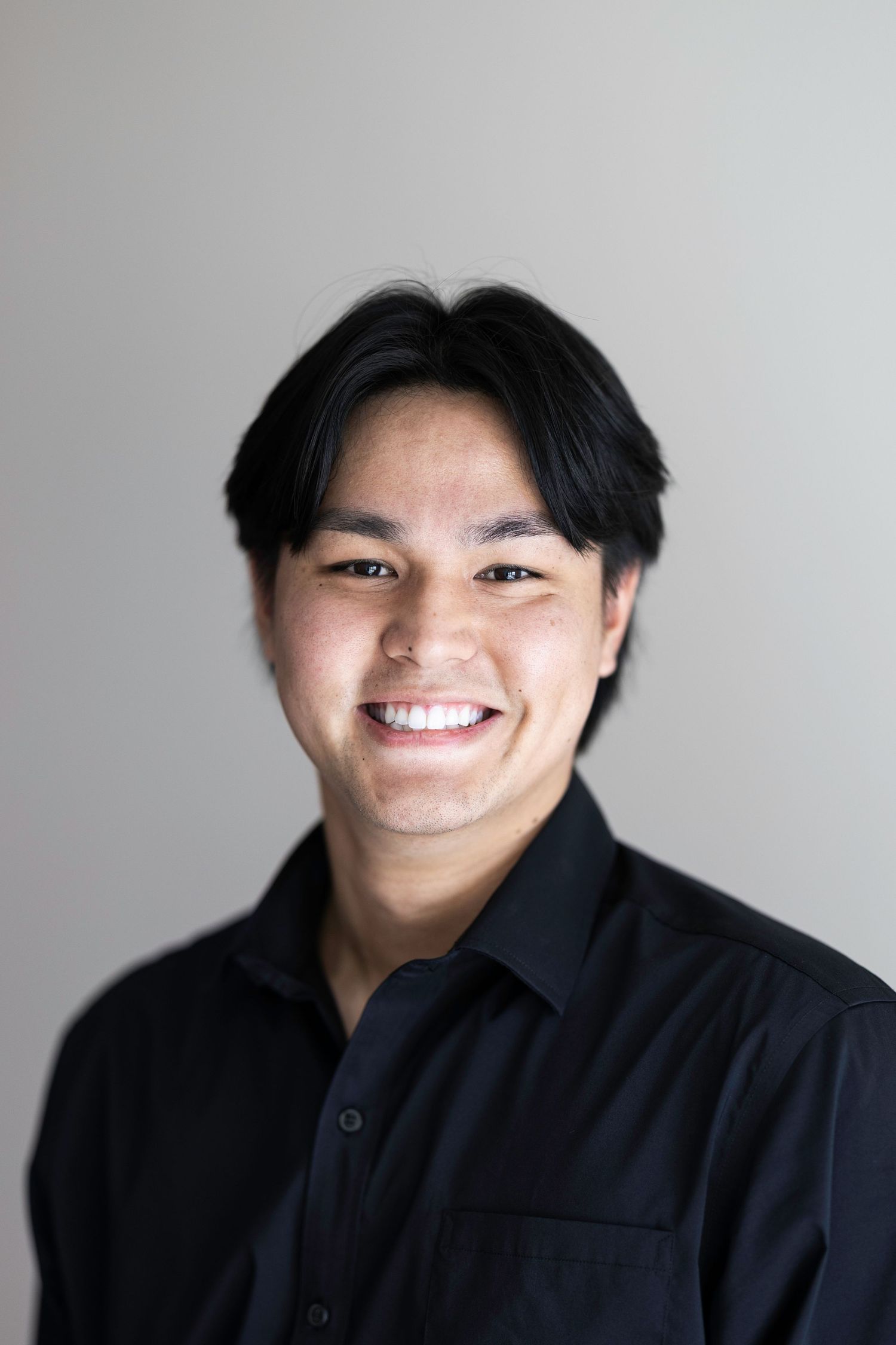 A series of black and white headshots showing expressions ranging from serious to joyful against a light background.