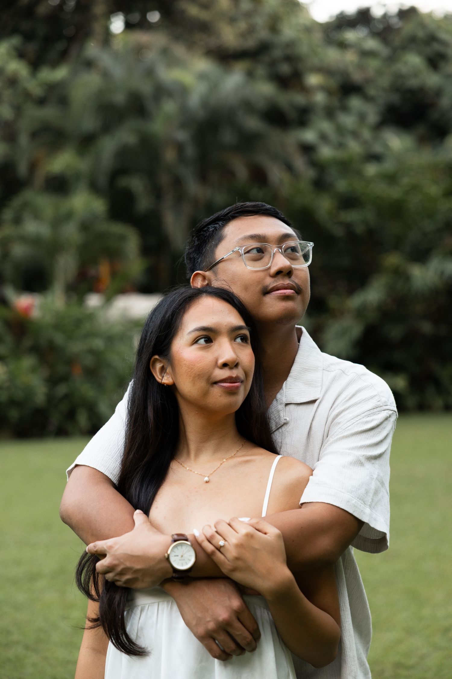A couple shares an intimate embrace while posing in a serene garden setting.