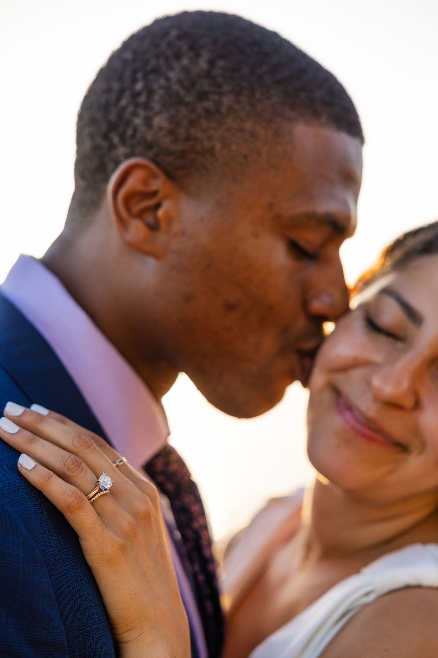 Intimate close-up shot of a couple sharing a tender moment at sunset.