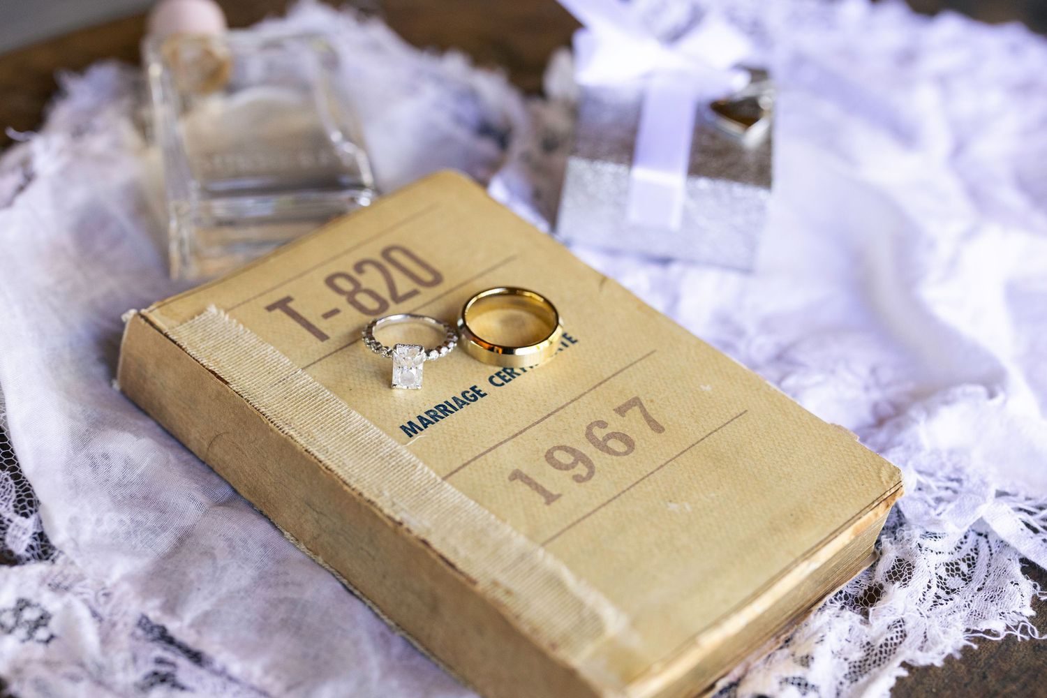 Gold wedding rings resting on a vintage book page with romantic text visible in soft lighting.