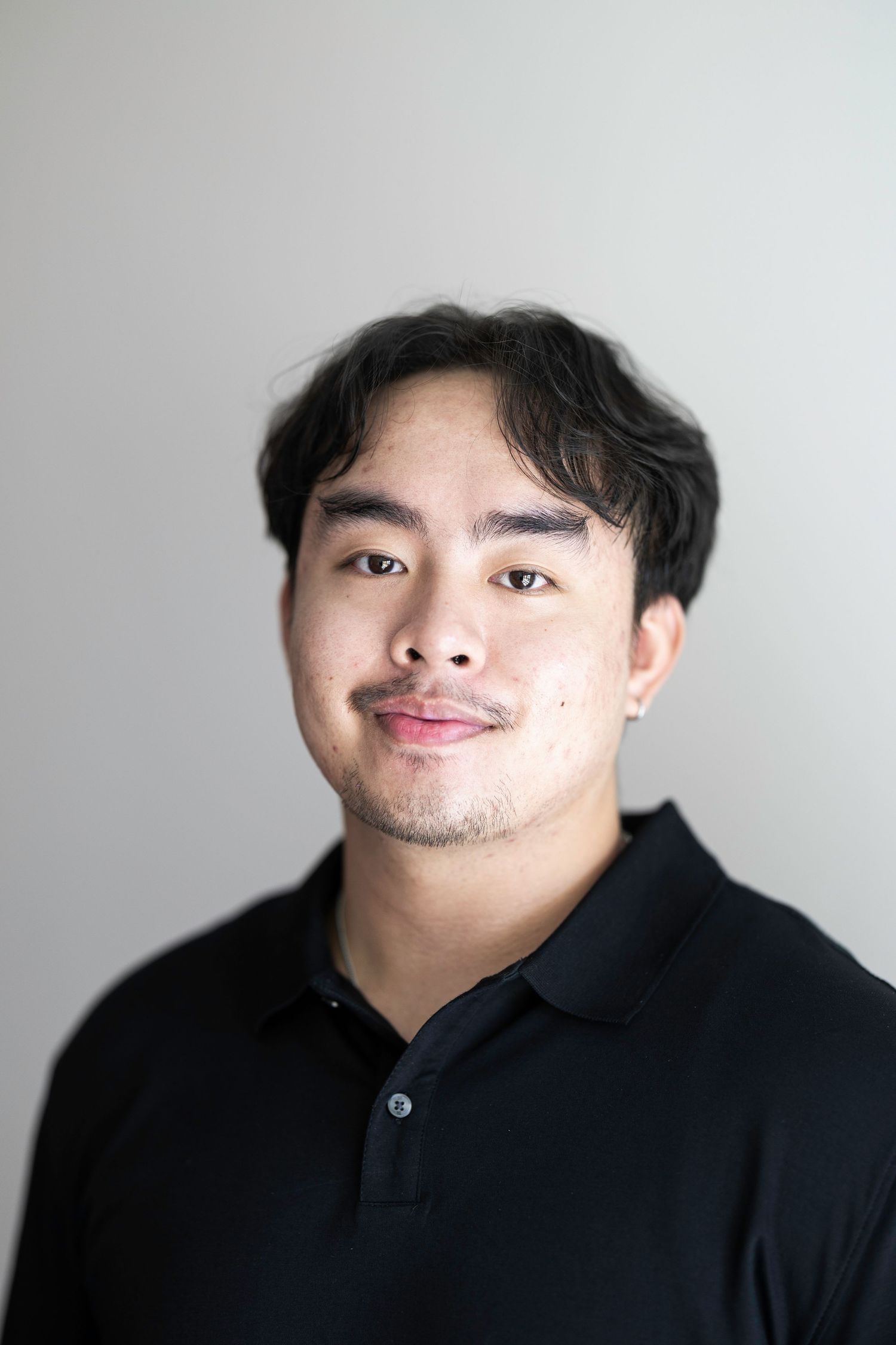 A series of close-up portraits showing someone in a black shirt making playful expressions against a light background.