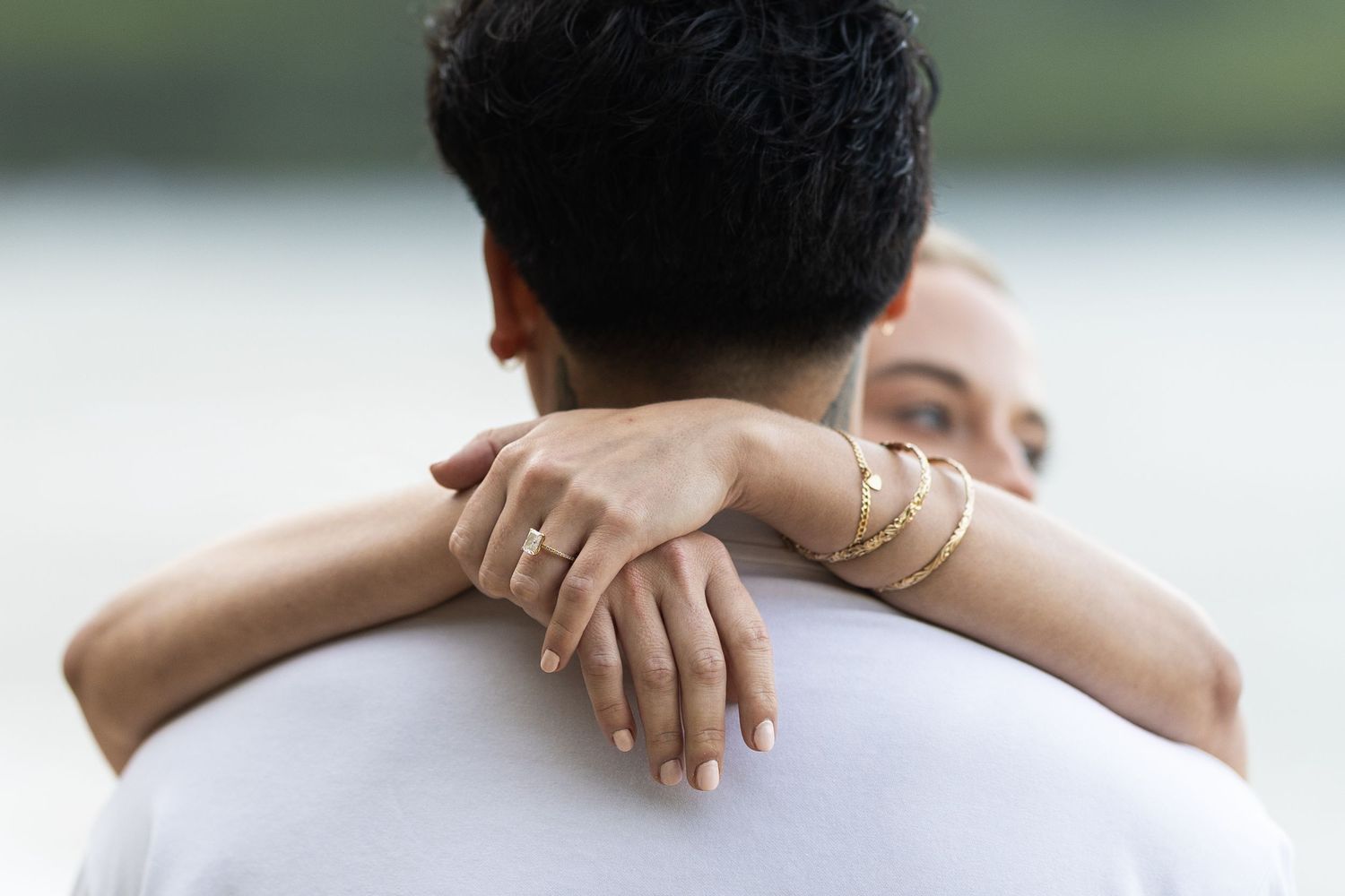 A group of people embracing in a supportive group hug outdoors.