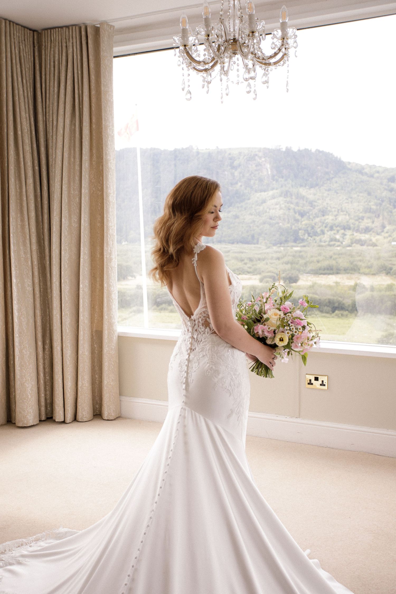 Elegant bridal portraits in a sunlit room with mountain views and flowing curtains.