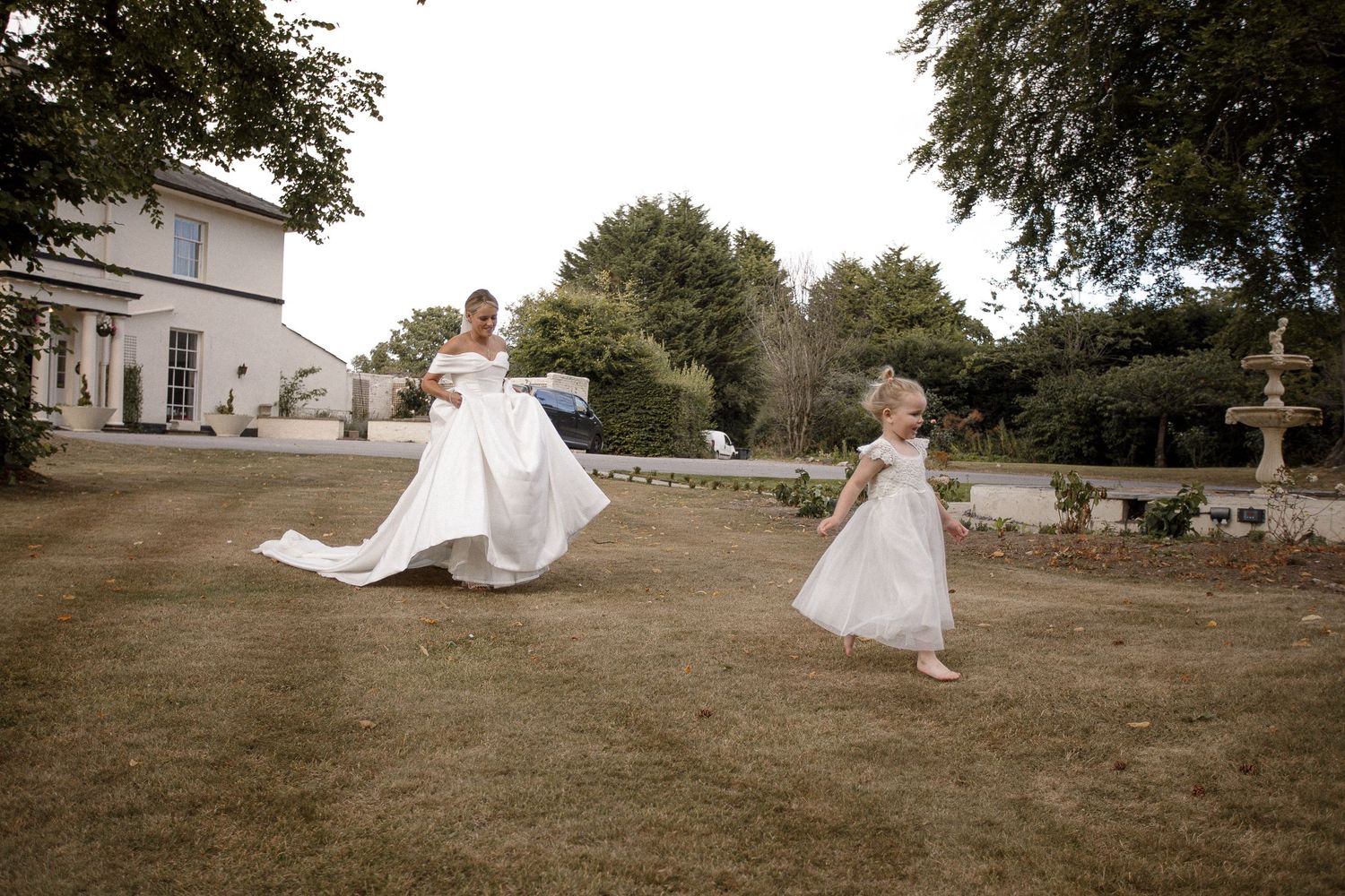 Wedding dress twirling in the breeze on a sunny garden lawn.