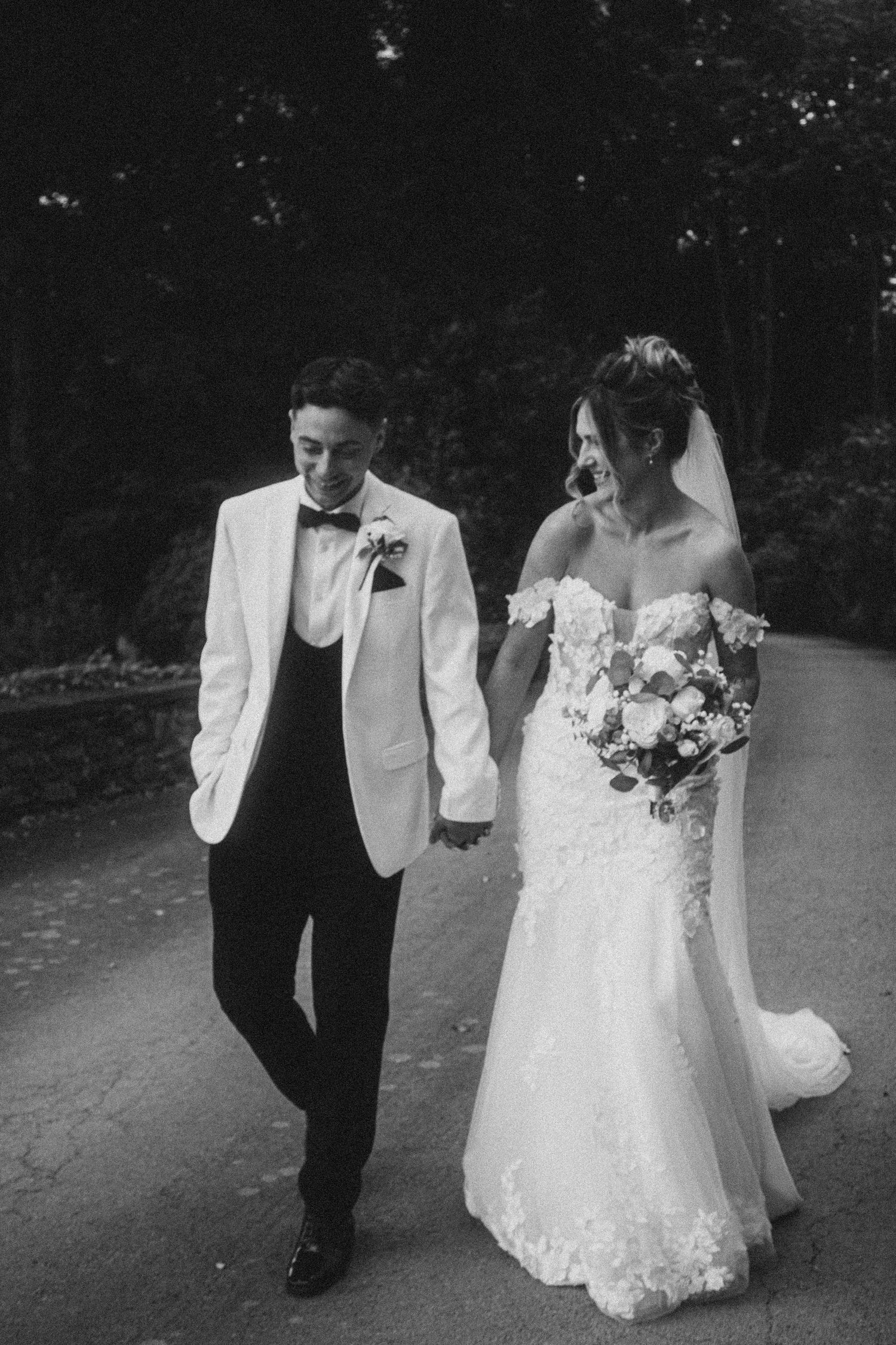 Black and white wedding photos showing a couple walking together on a garden path.