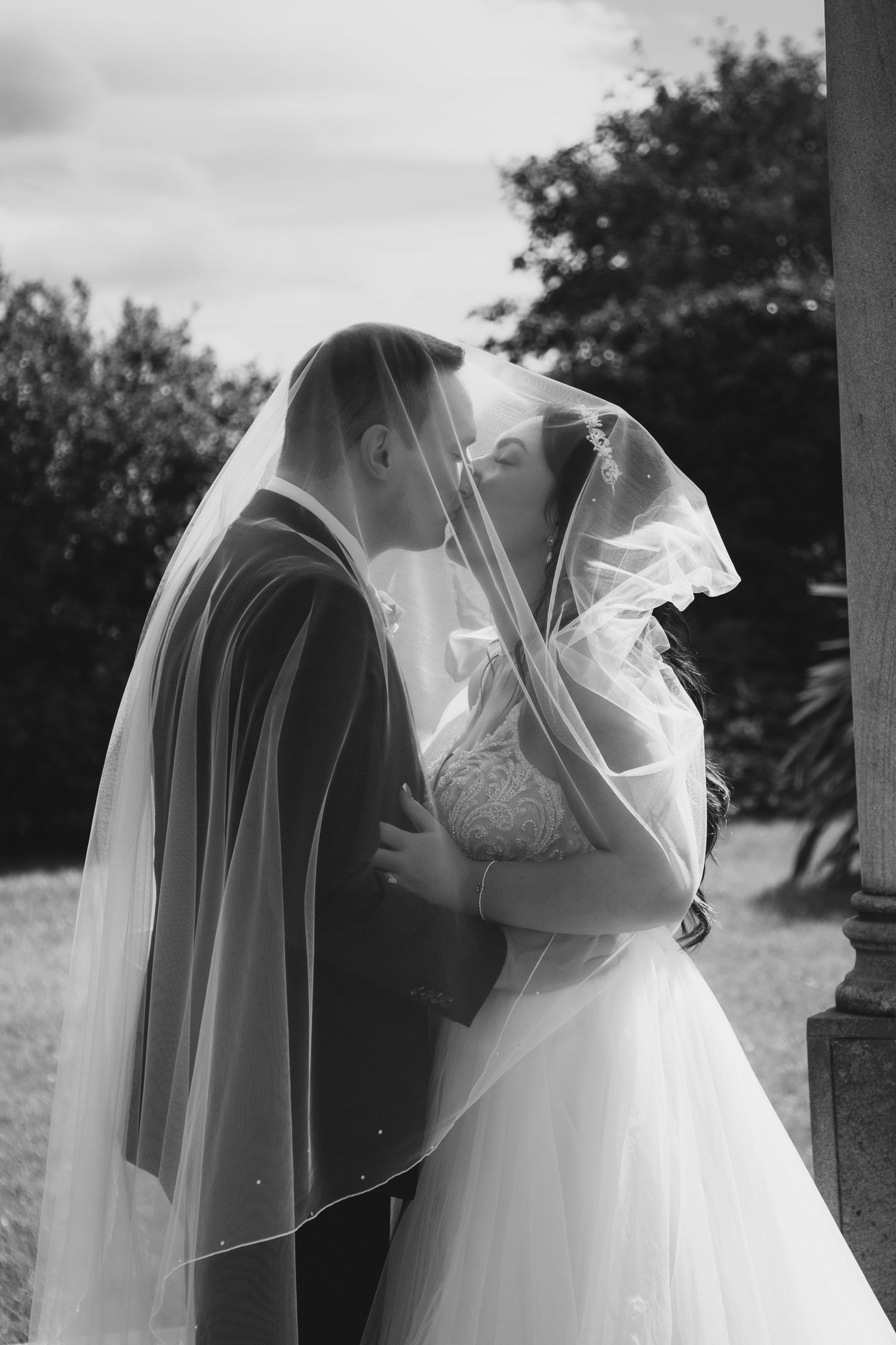 Romantic black and white wedding portraits with flowing veil.
