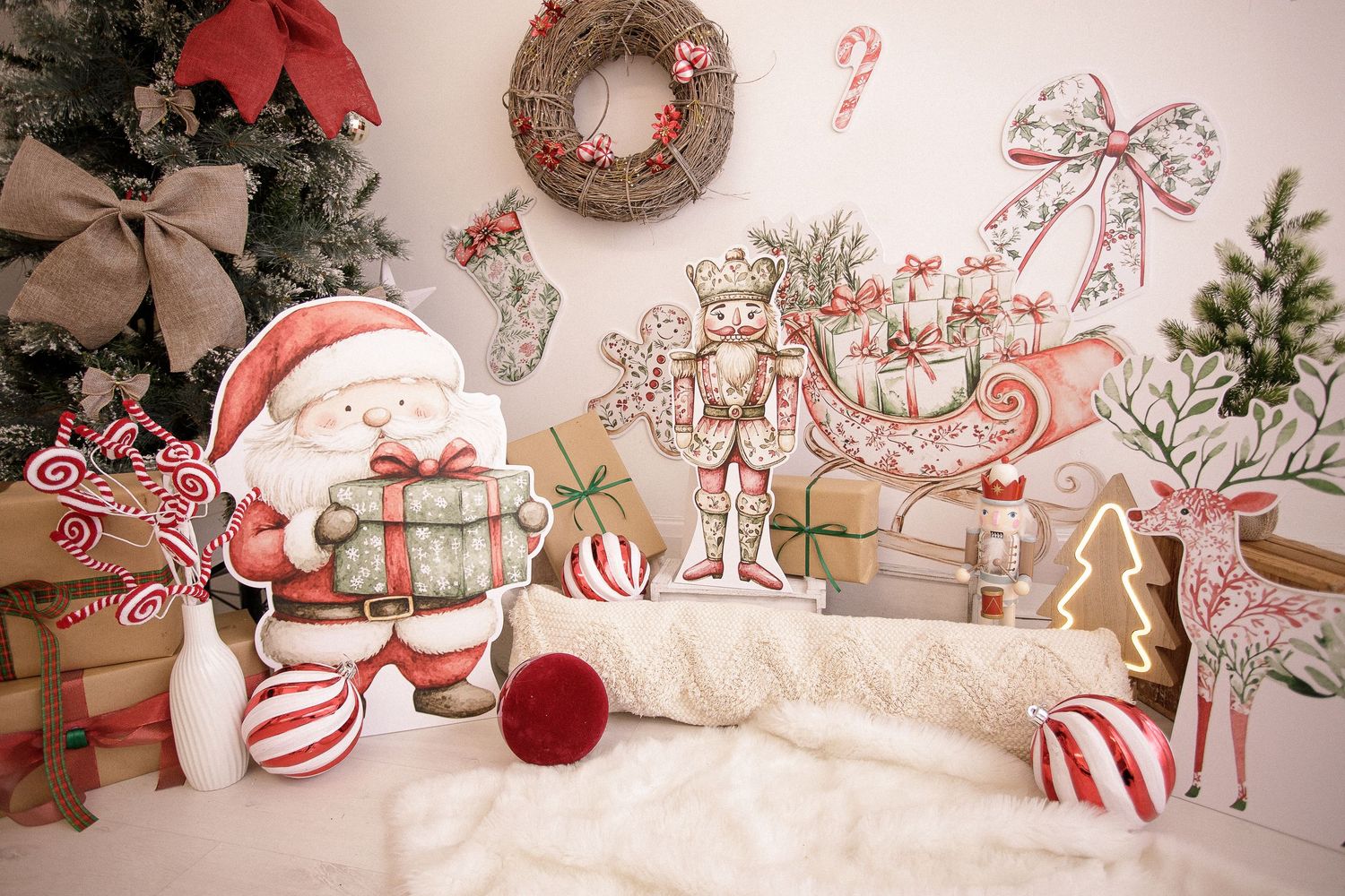 Christmas decorations including wrapped presents, red bows, and festive ornaments arranged on white faux fur.