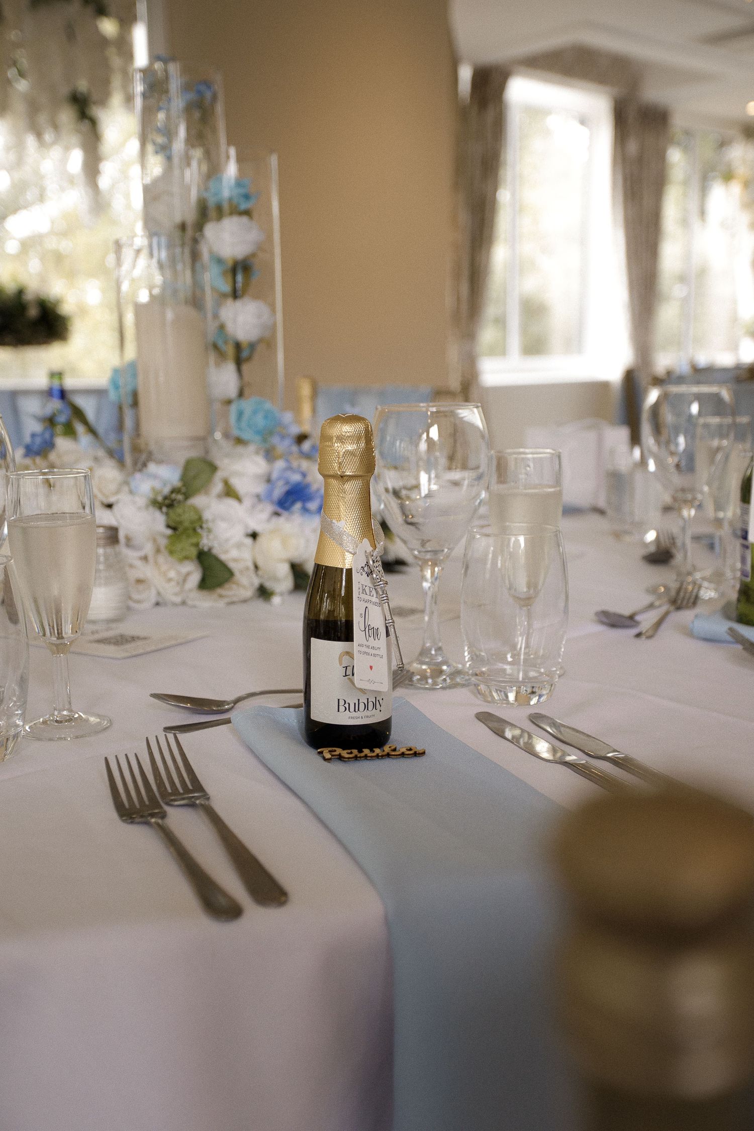 Elegant wedding reception table settings with white linens and champagne glasses.