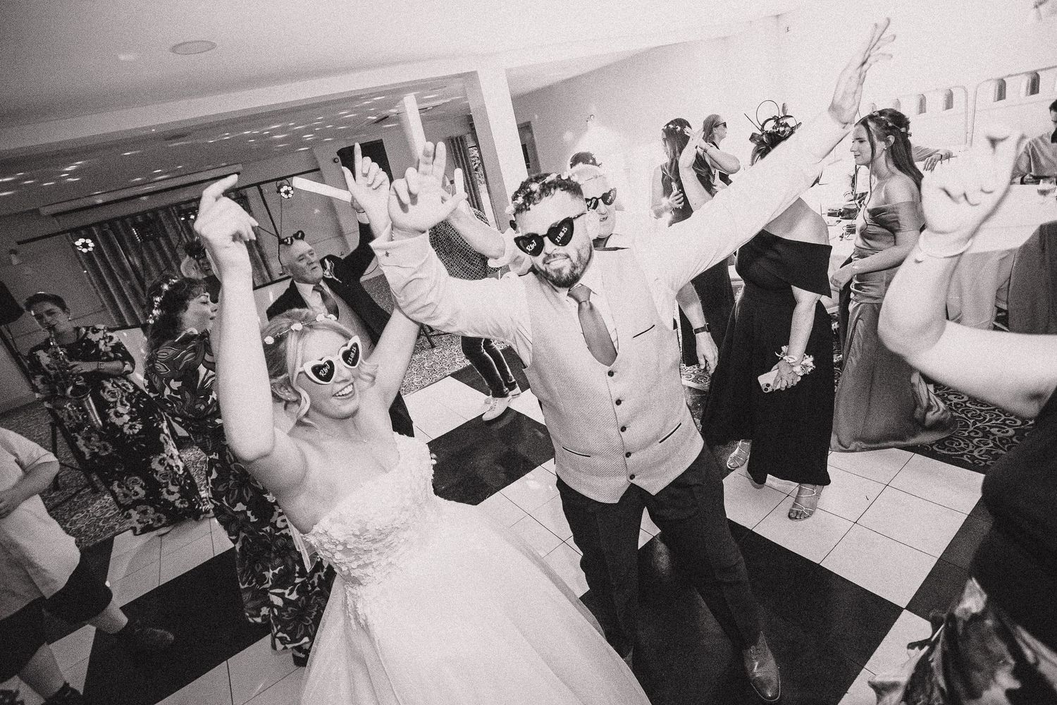 Wedding celebration with guests dancing and having fun at a reception venue.