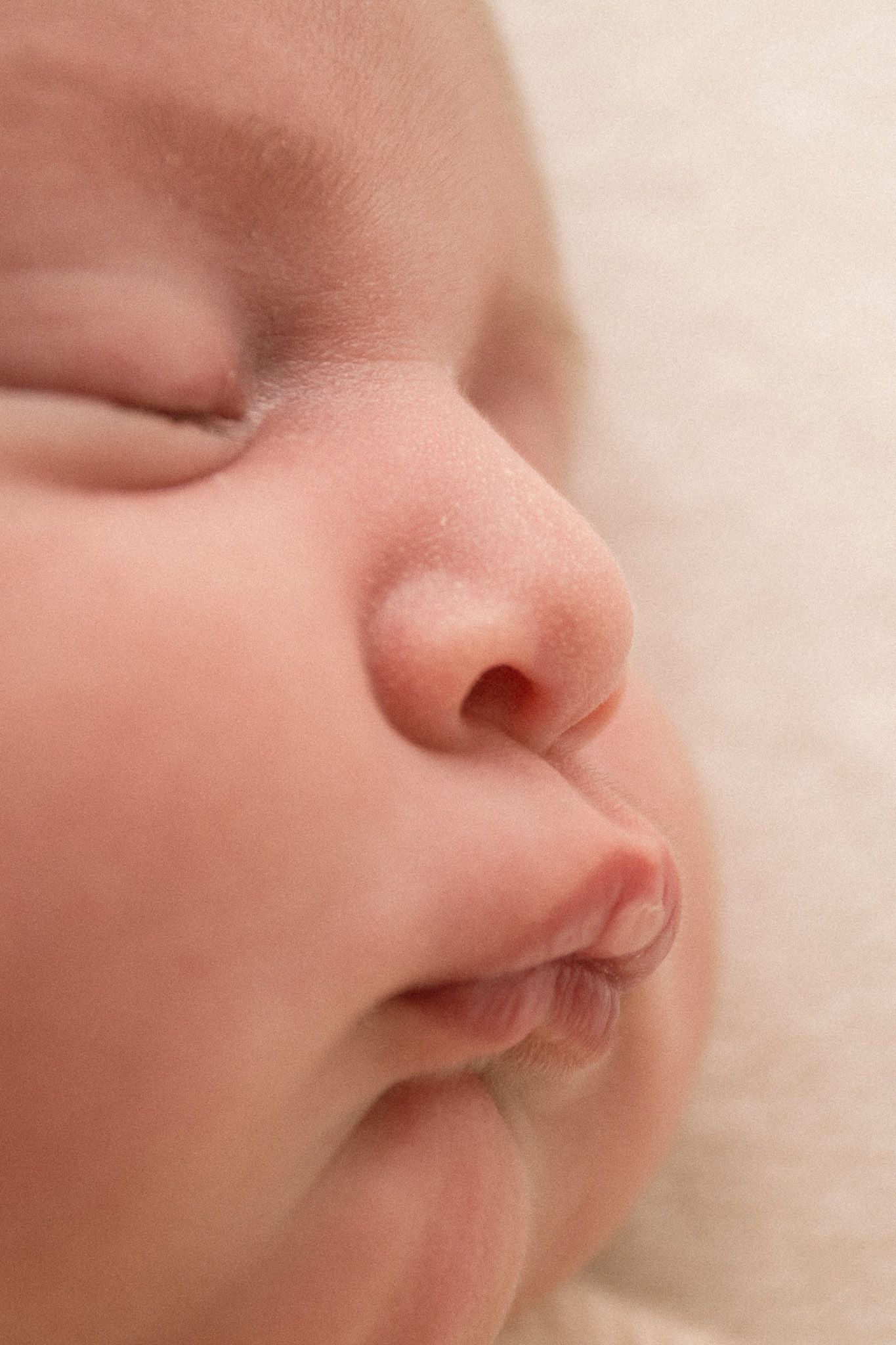 Extreme closeup of peaceful sleeping baby's face showing nose and lips.