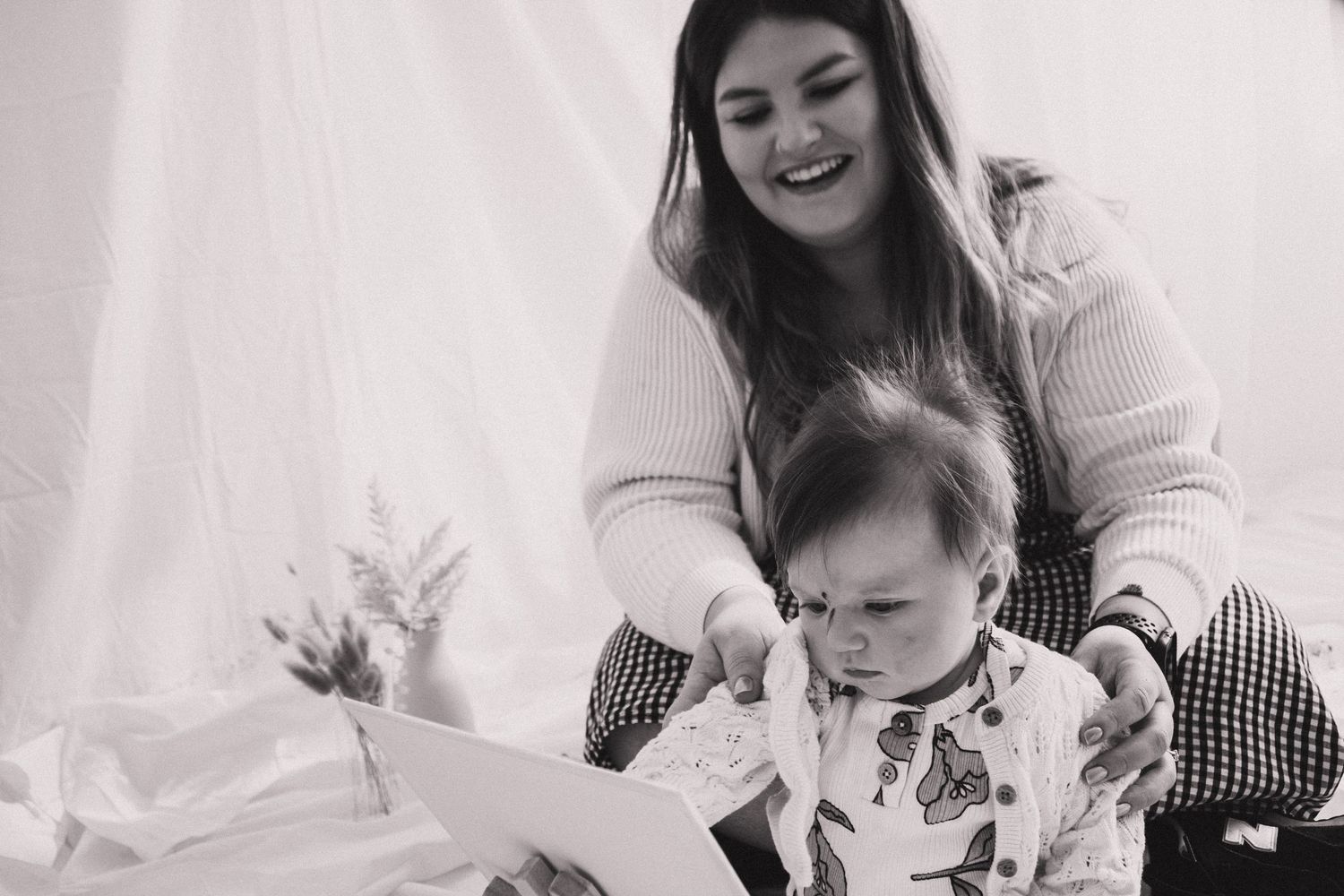 A series of black and white photographs showing tender moments between a parent and child at home.