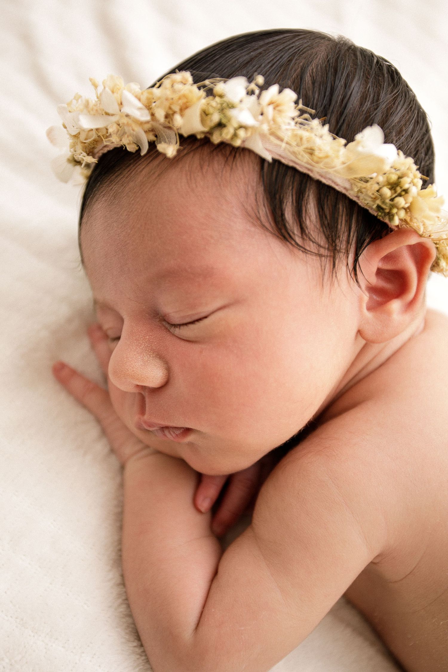 Peaceful newborn portrait with delicate dried flower crown.