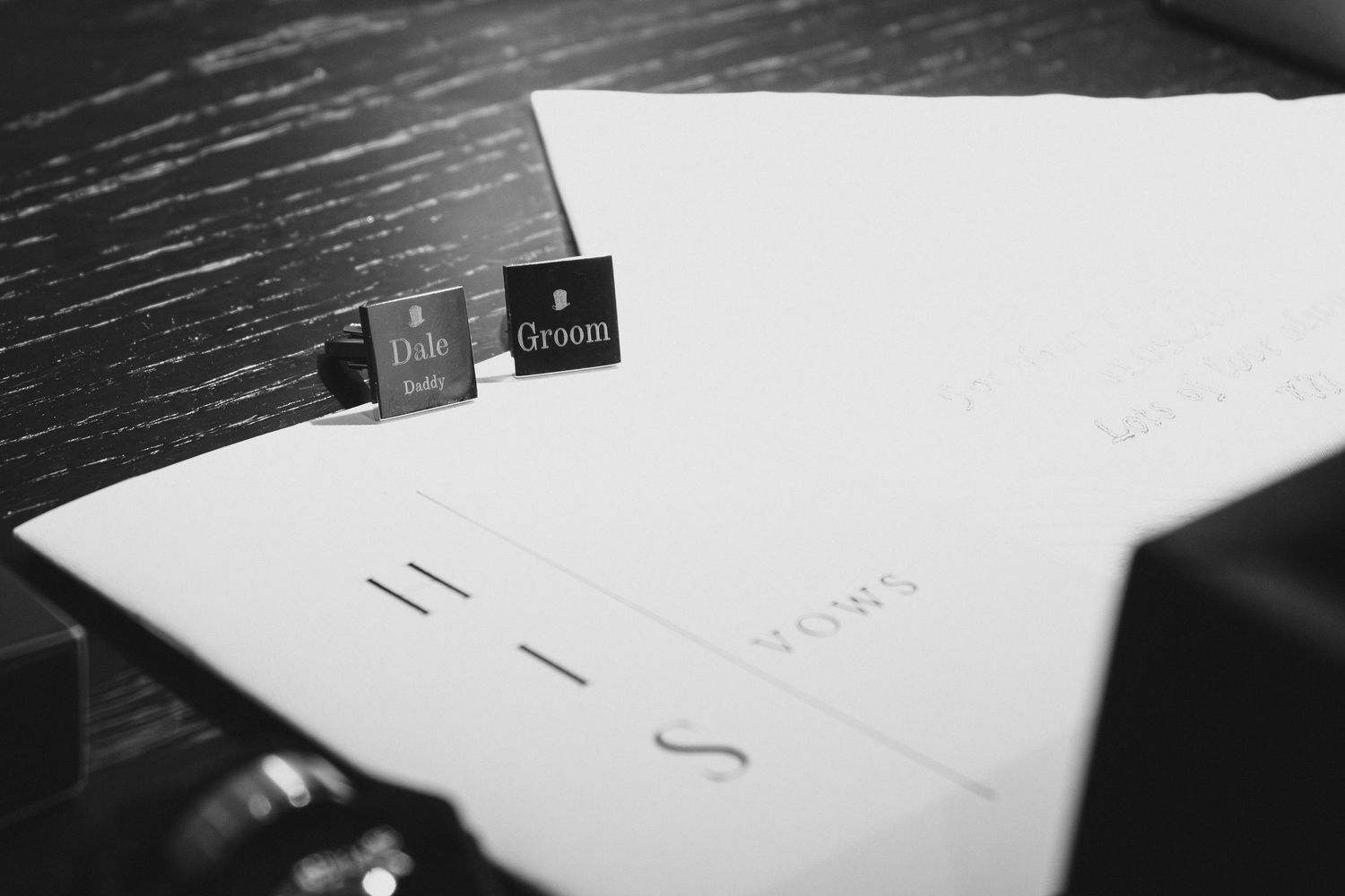 Close-up of wedding document signing on dark wooden surface.