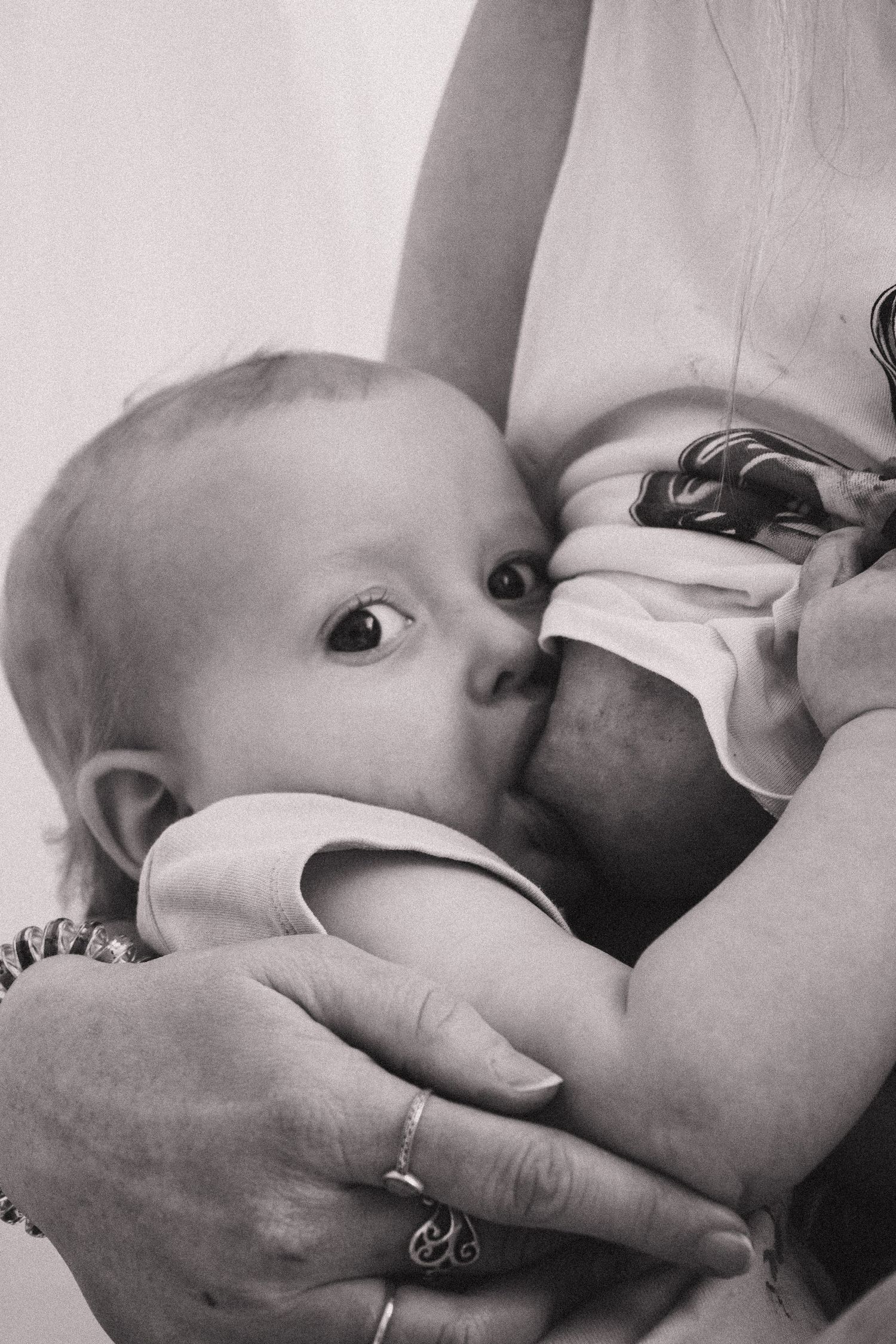 Intimate black and white series of nursing moments between parent and baby.