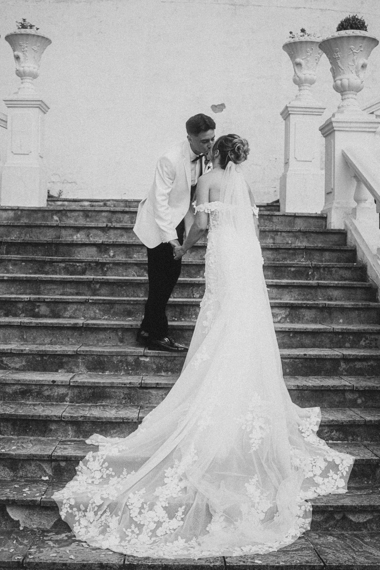 Black and white photos capturing intimate moments on elegant stone steps.
