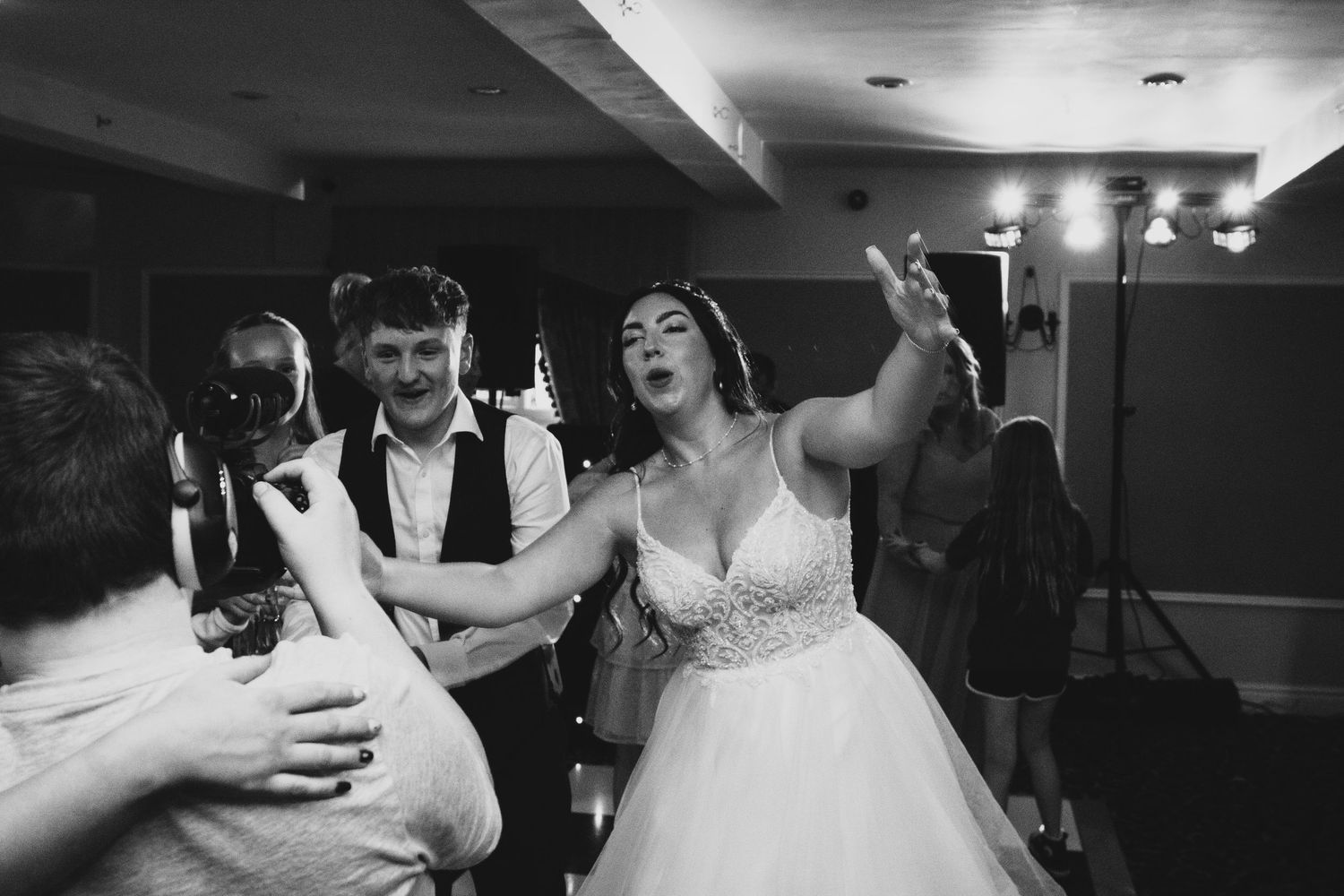 Black and white shots of lively wedding reception dance floor.