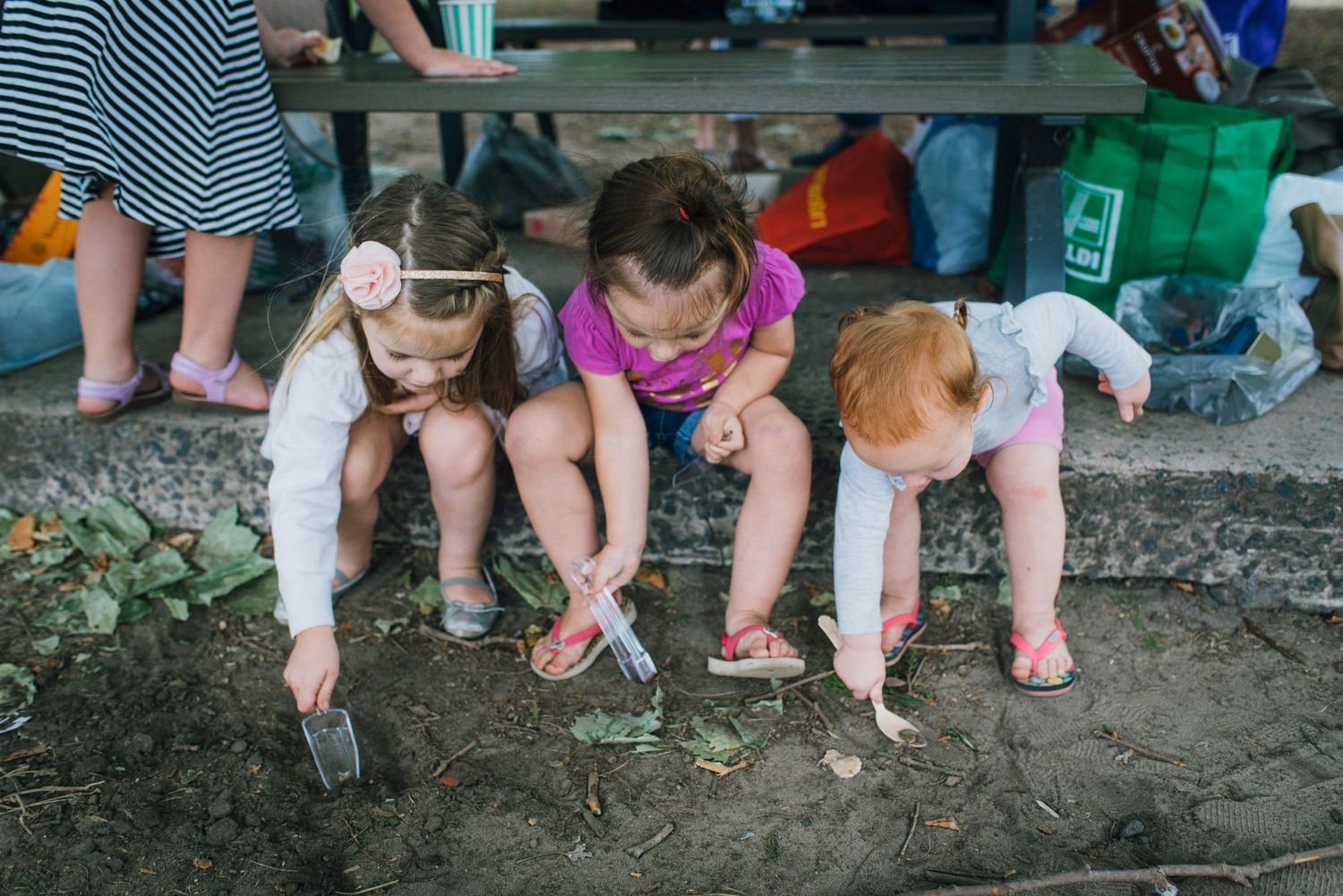 Three little girls playing in the dirt during engagement party in Centennial Park - Zara King Photography, Sydney Australia